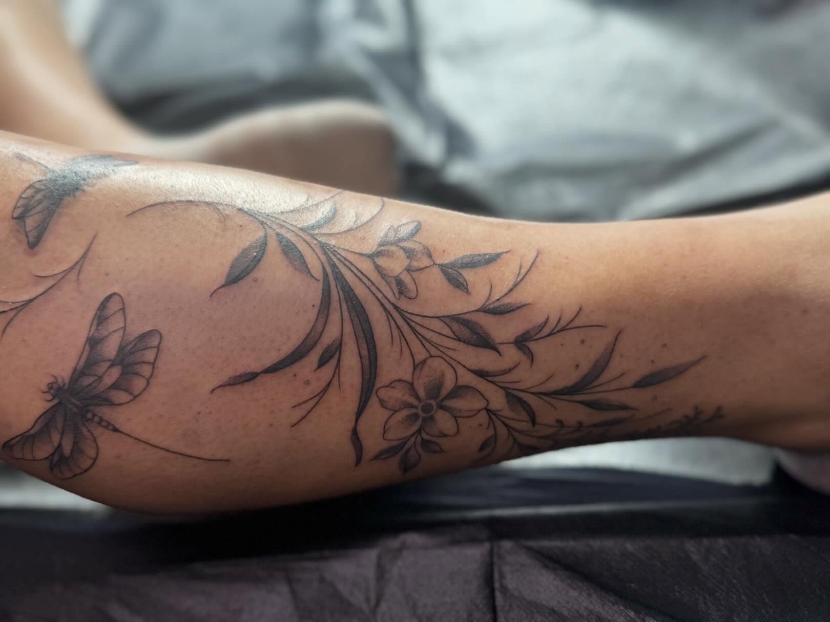 Floral and dragonfly black and grey tattoo on the forearm by Tattoo, San Diego, California
