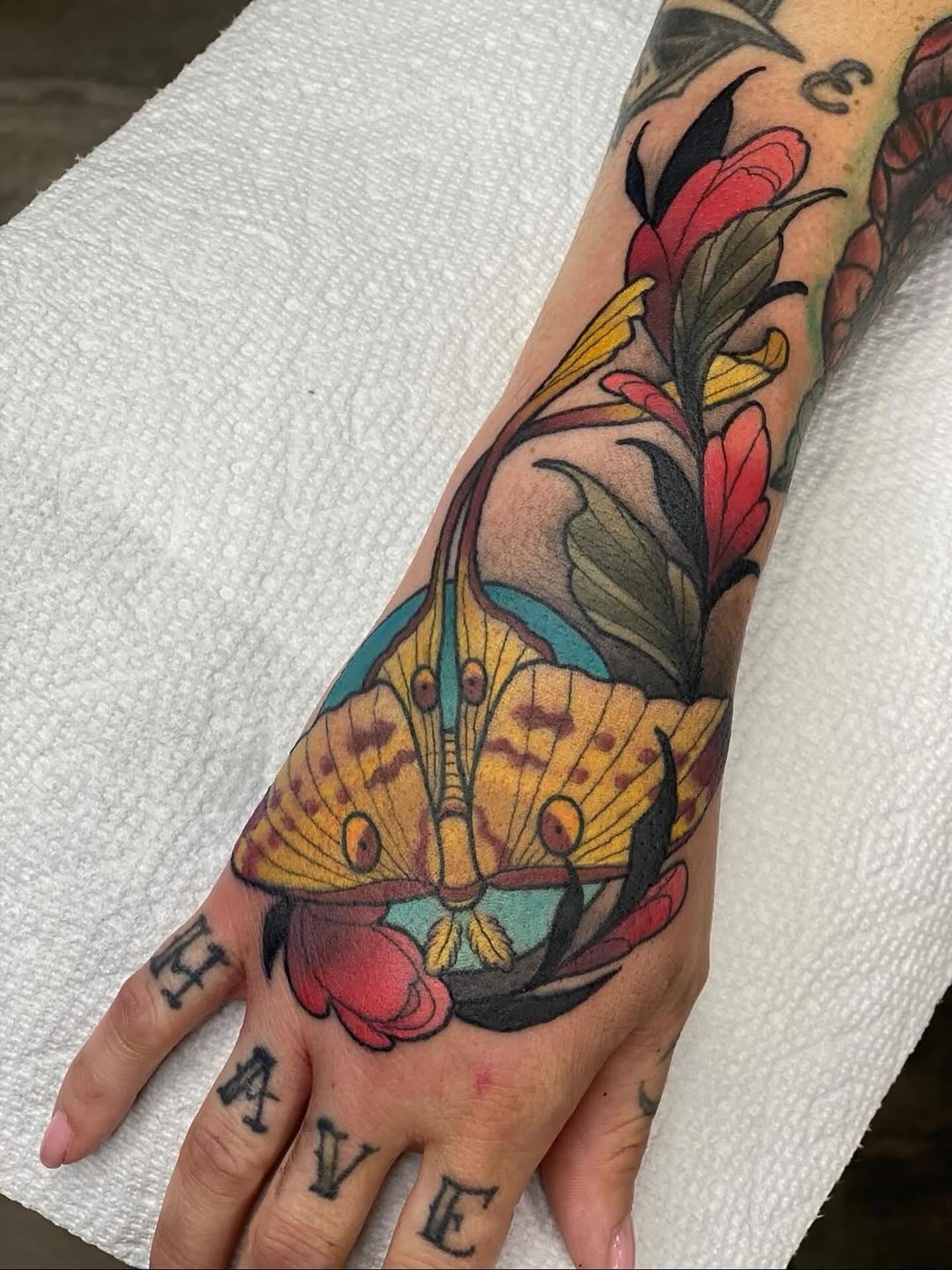 Butterfly and flowers American traditional tattoo on the hand by Kyle Behr
