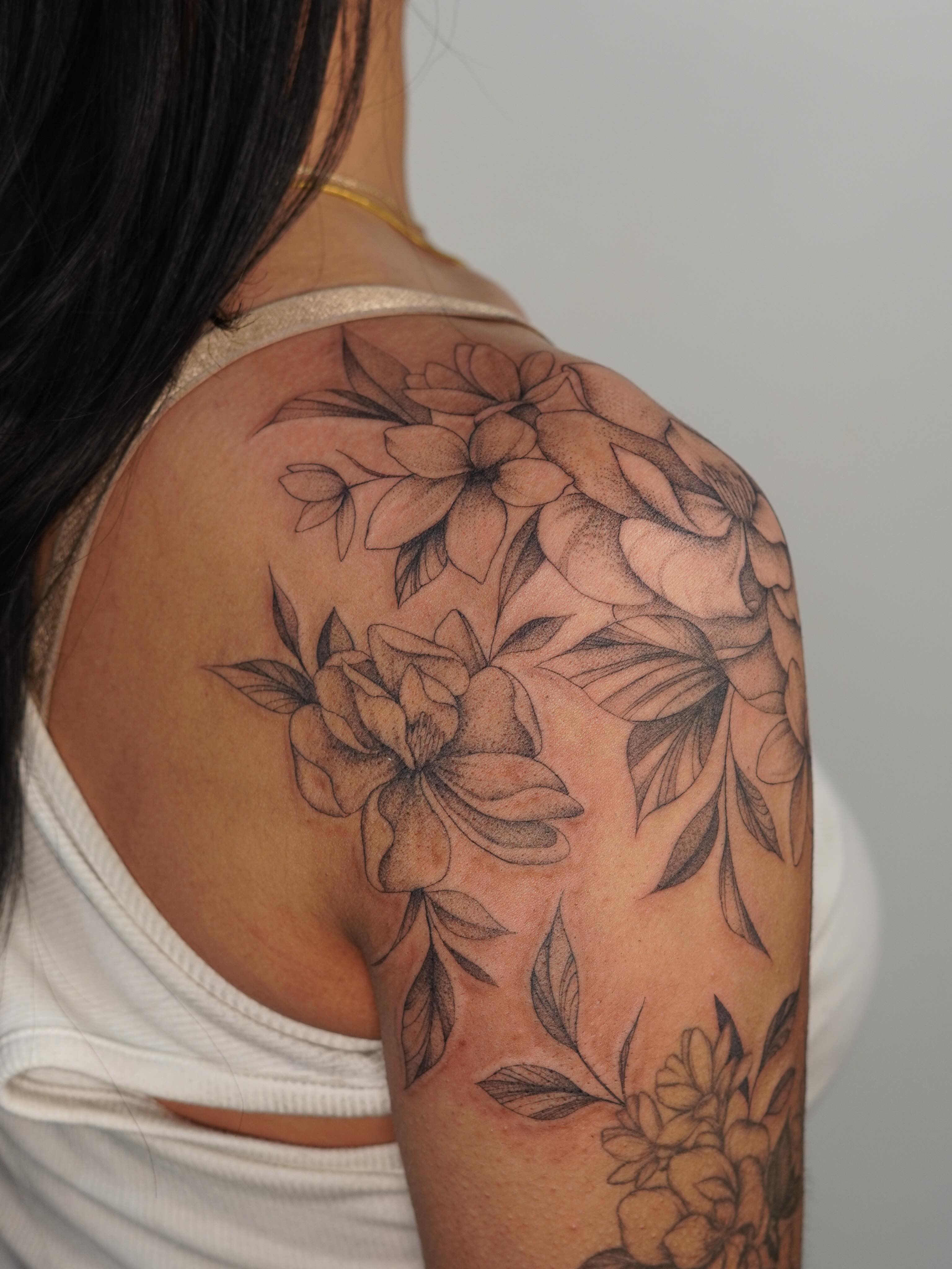 Floral arrangement black and grey tattoo on the shoulder by Danae Andino