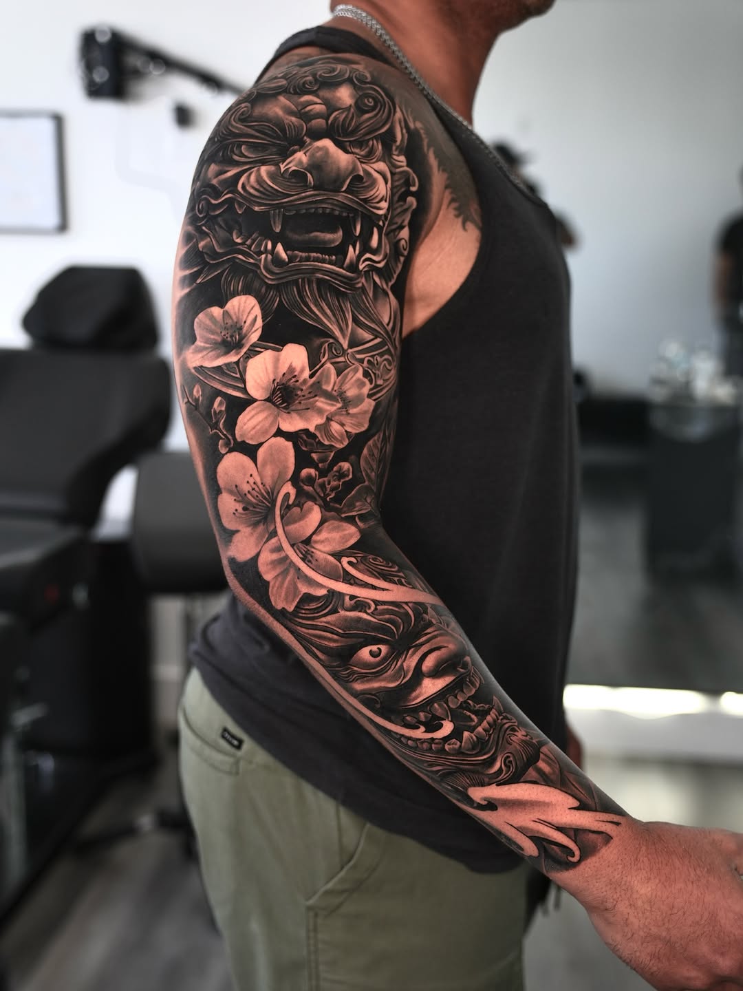 Foo dog and cherry blossoms Japanese tattoo on the upper arm by Luis Manuel Olivera, North Miami, Florida