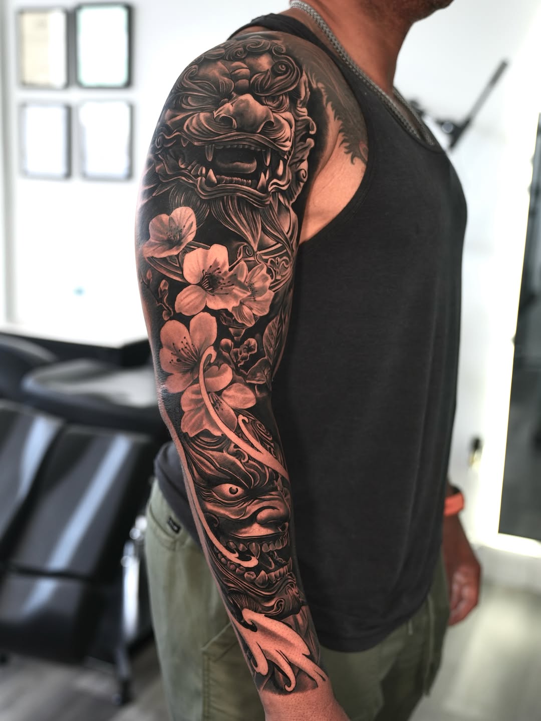 Foo dog and cherry blossoms Japanese tattoo on the upper arm by Luis Manuel Olivera, North Miami, Florida