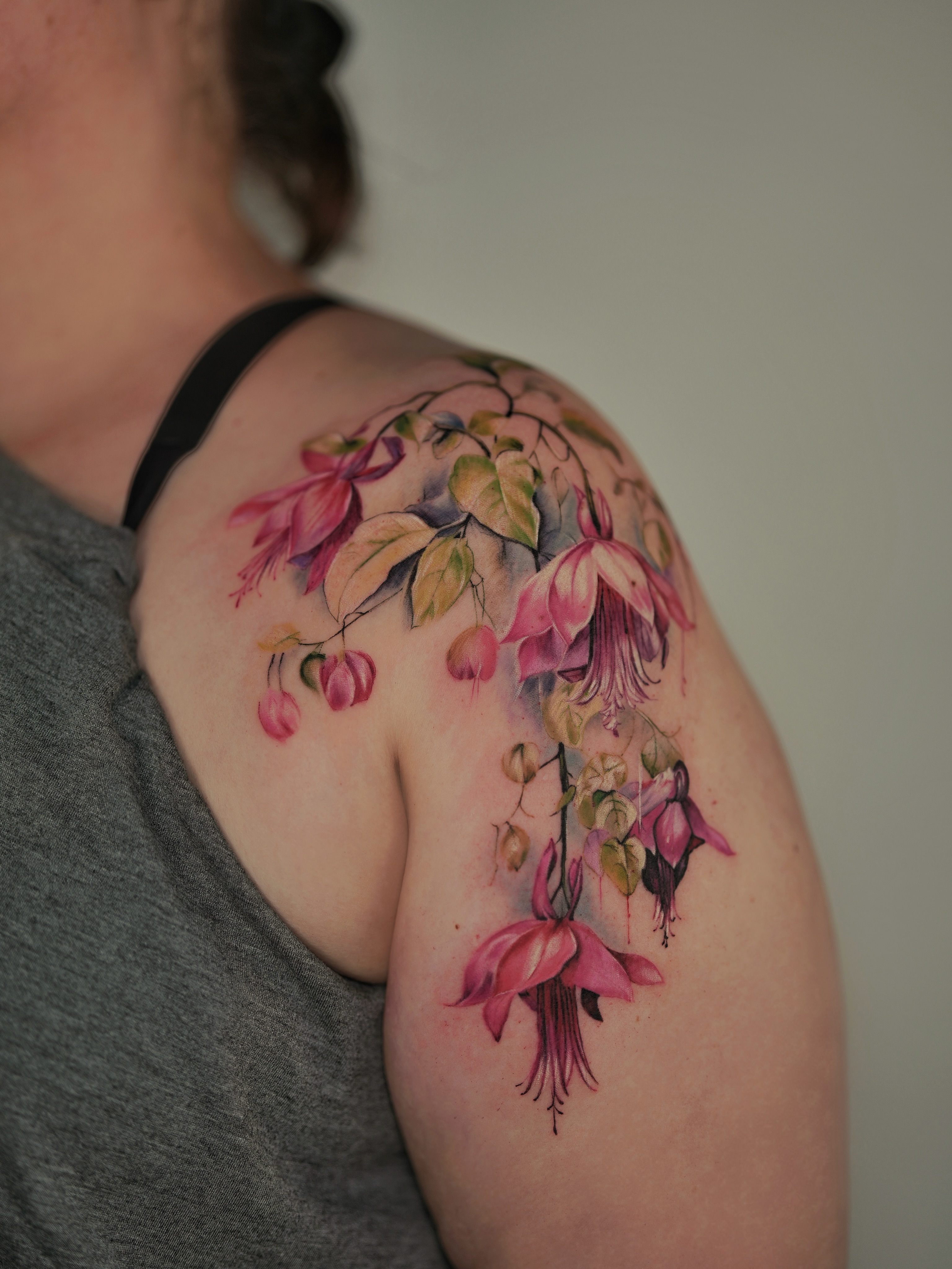 Fuchsia flowers realism tattoo on the shoulder by Henry