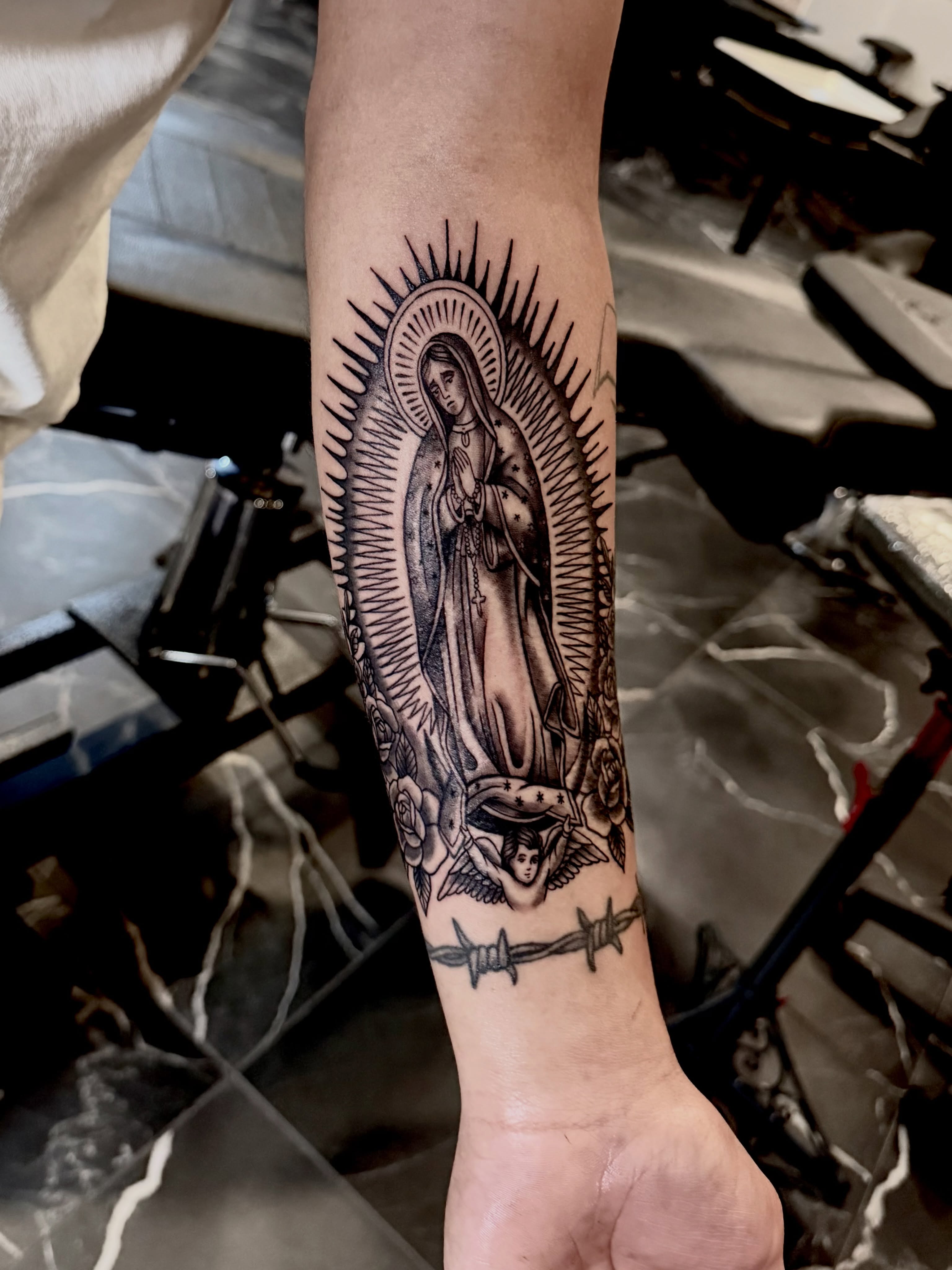 Our Lady of Guadalupe black and grey tattoo on the forearm by Barbara Gonzalez
