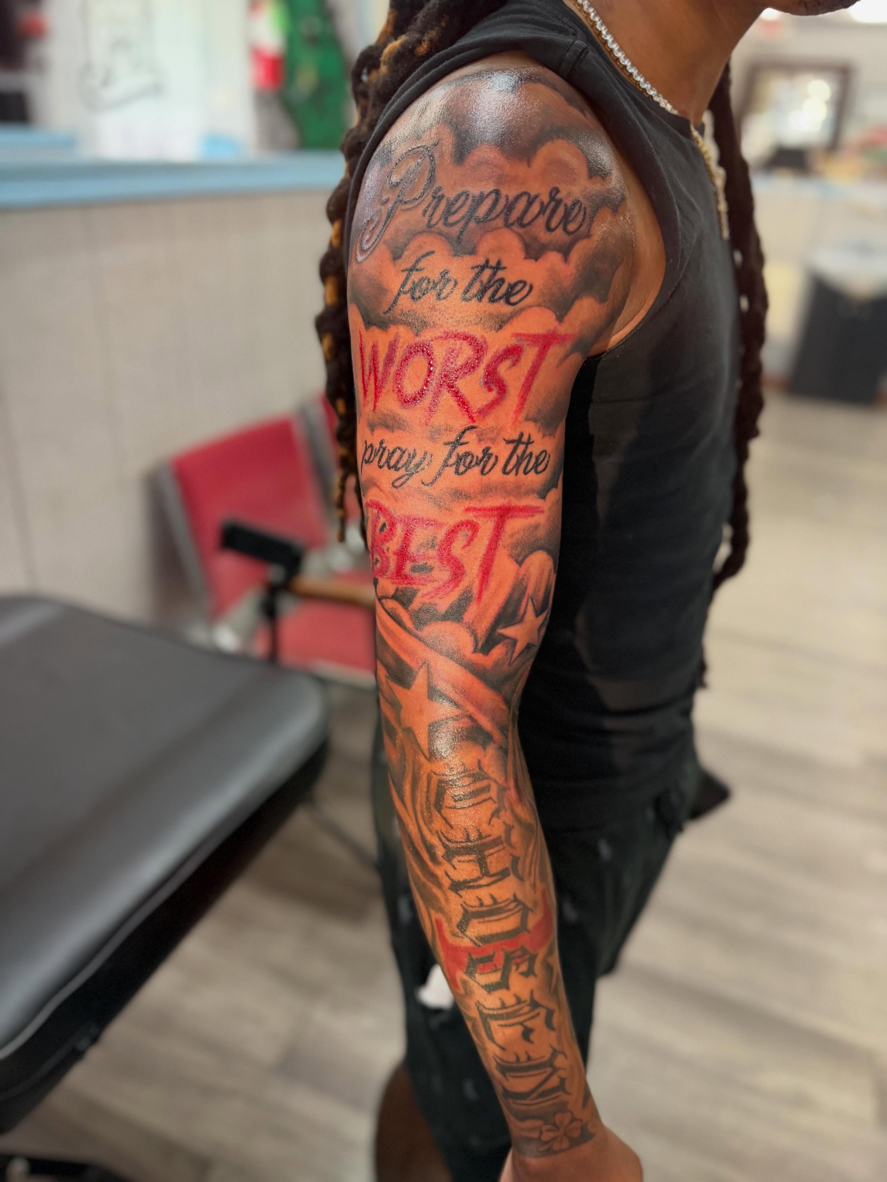 Text and clouds lettering script tattoo on the upper arm by JAE, Shreveport, Louisiana