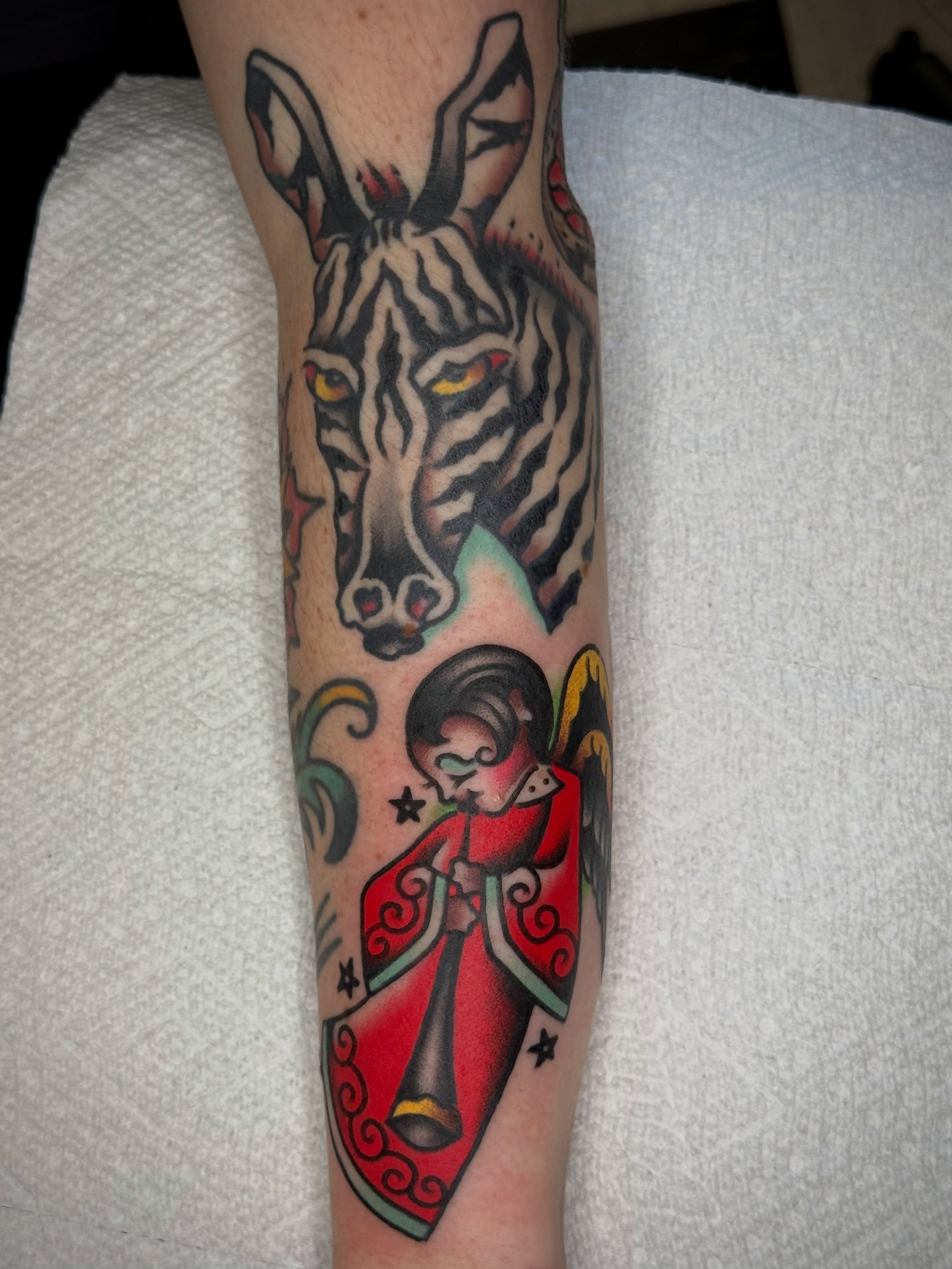 Zebra and jester American traditional tattoo on the forearm by Maximilian Harrison