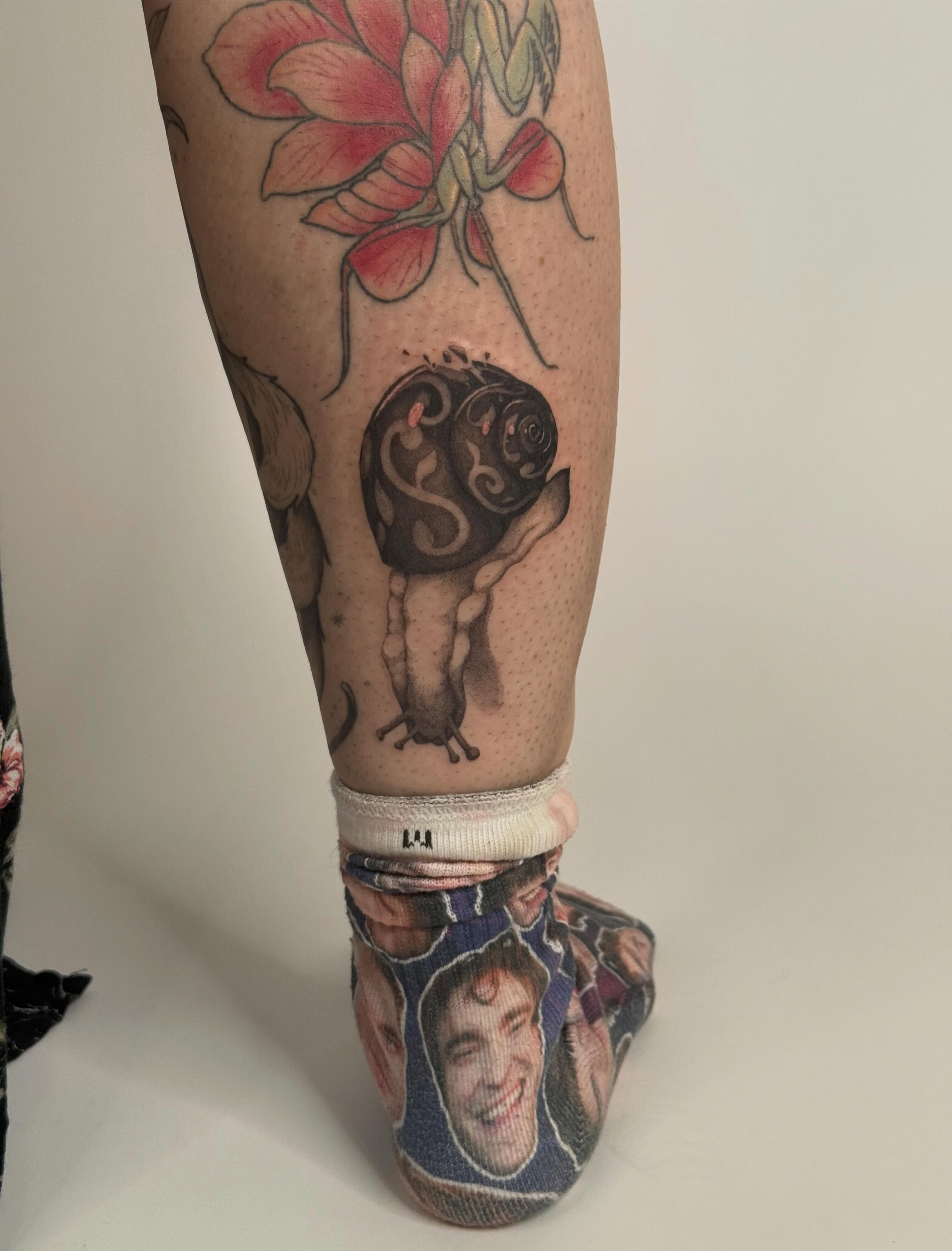 Snail and flower dotwork tattoo on the calf by Andrew Flatts