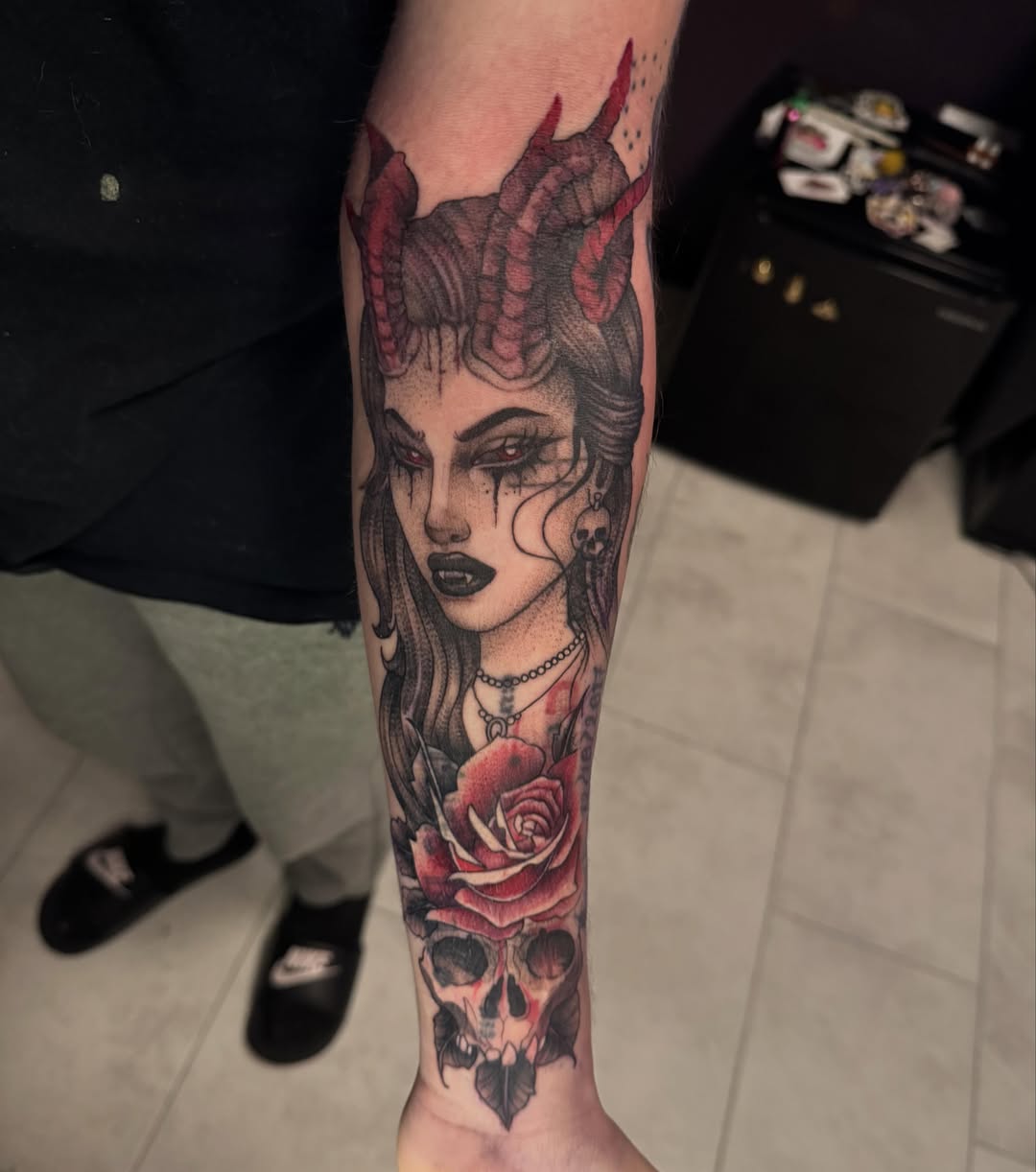 Woman with horns and rose dark realism tattoo on the forearm by Lindsay