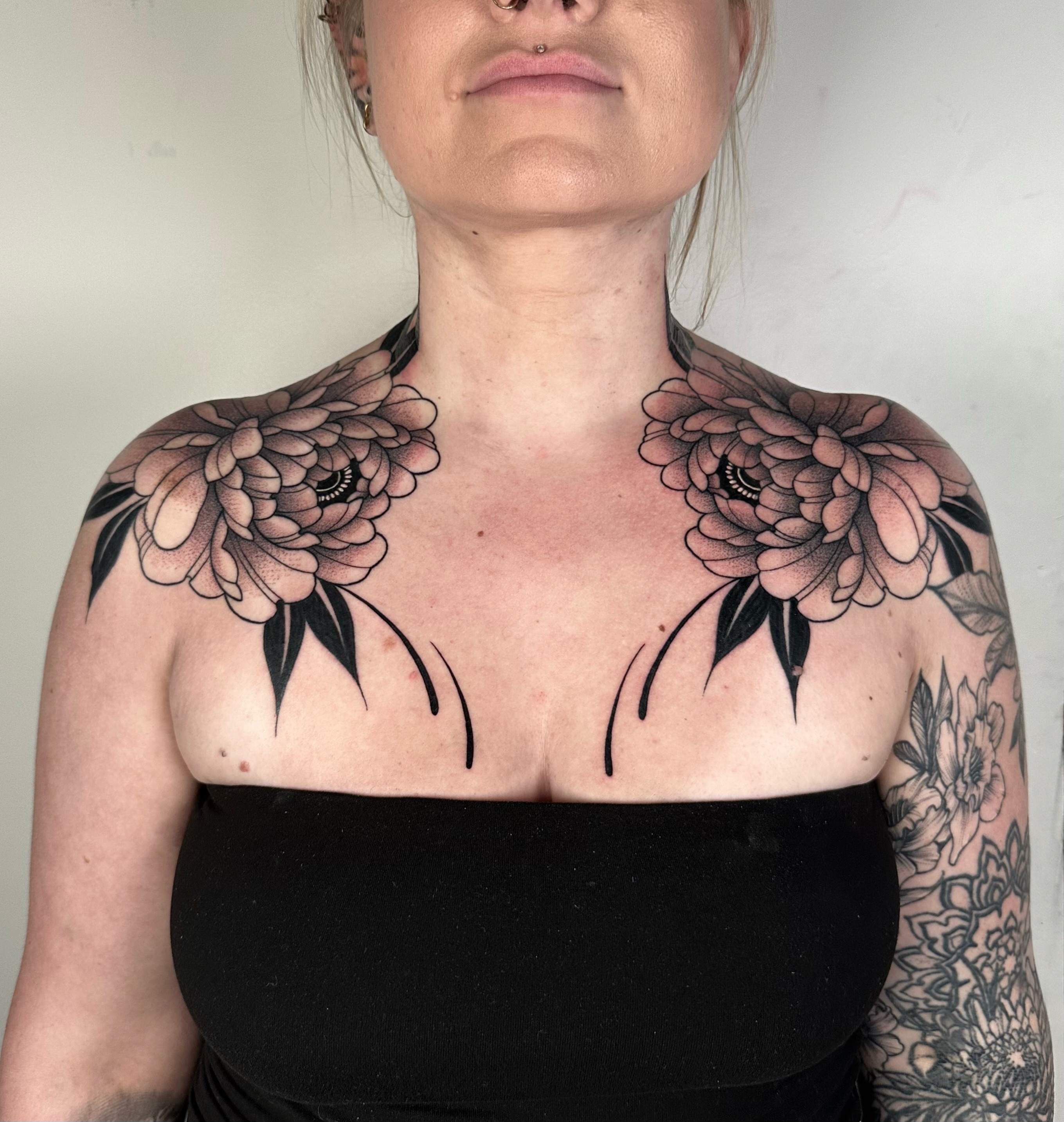 Peony flowers black and grey tattoo on the chest by Brooklyn Bailey