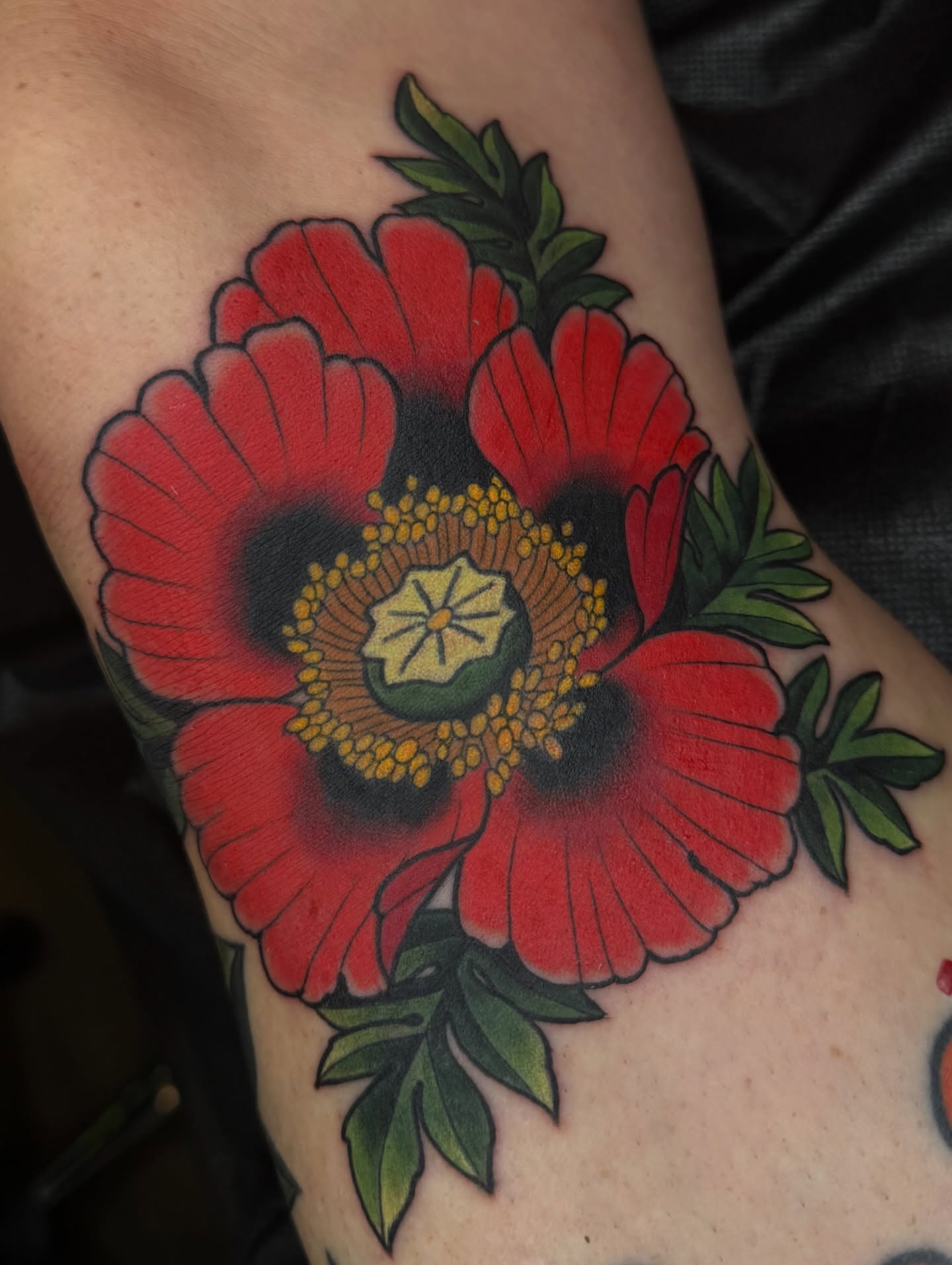 Red poppies American traditional tattoo on the forearm by Anna Wall