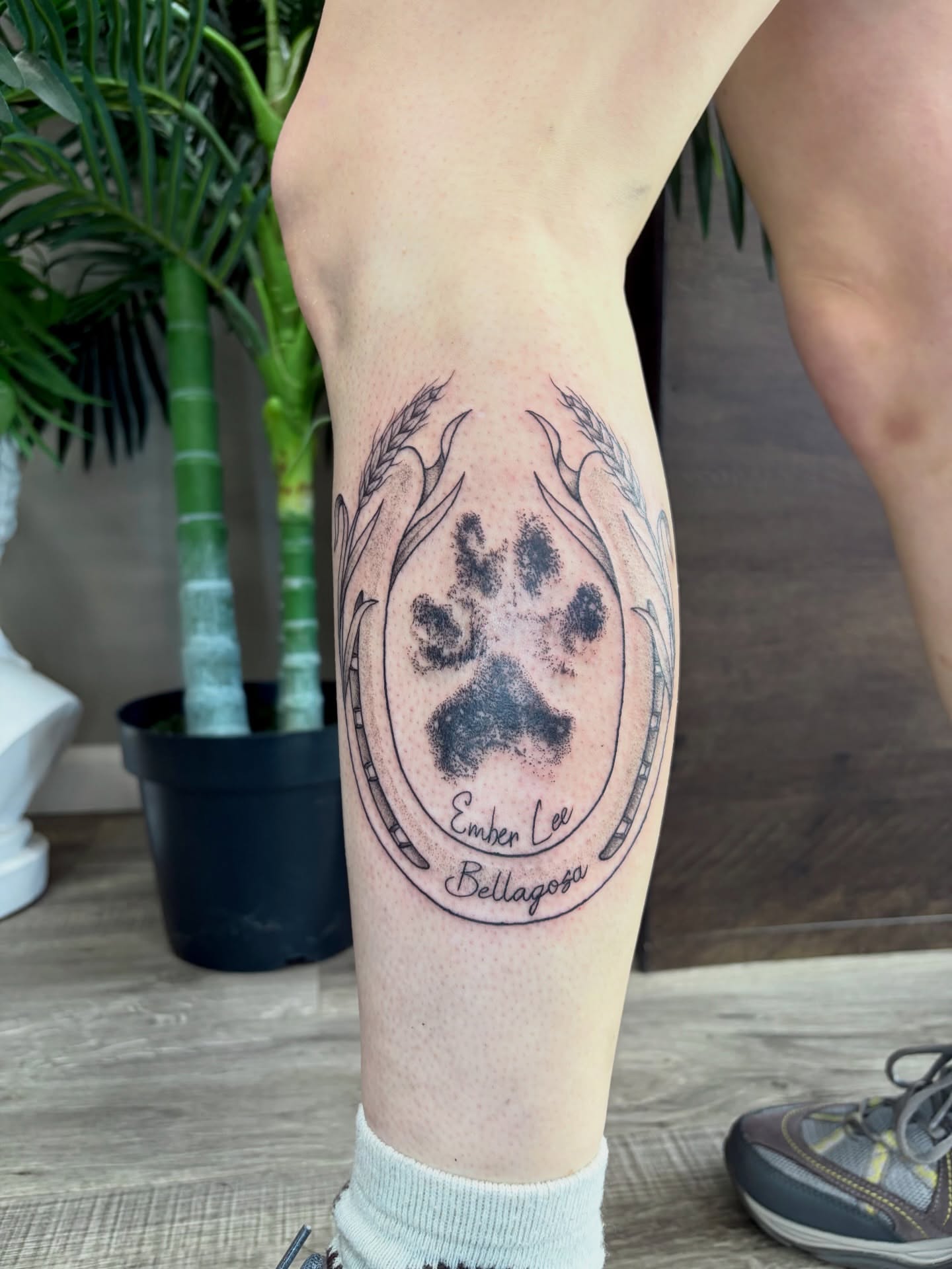 Paw print black and grey tattoo on the calf by Taylor Heidtbrink
