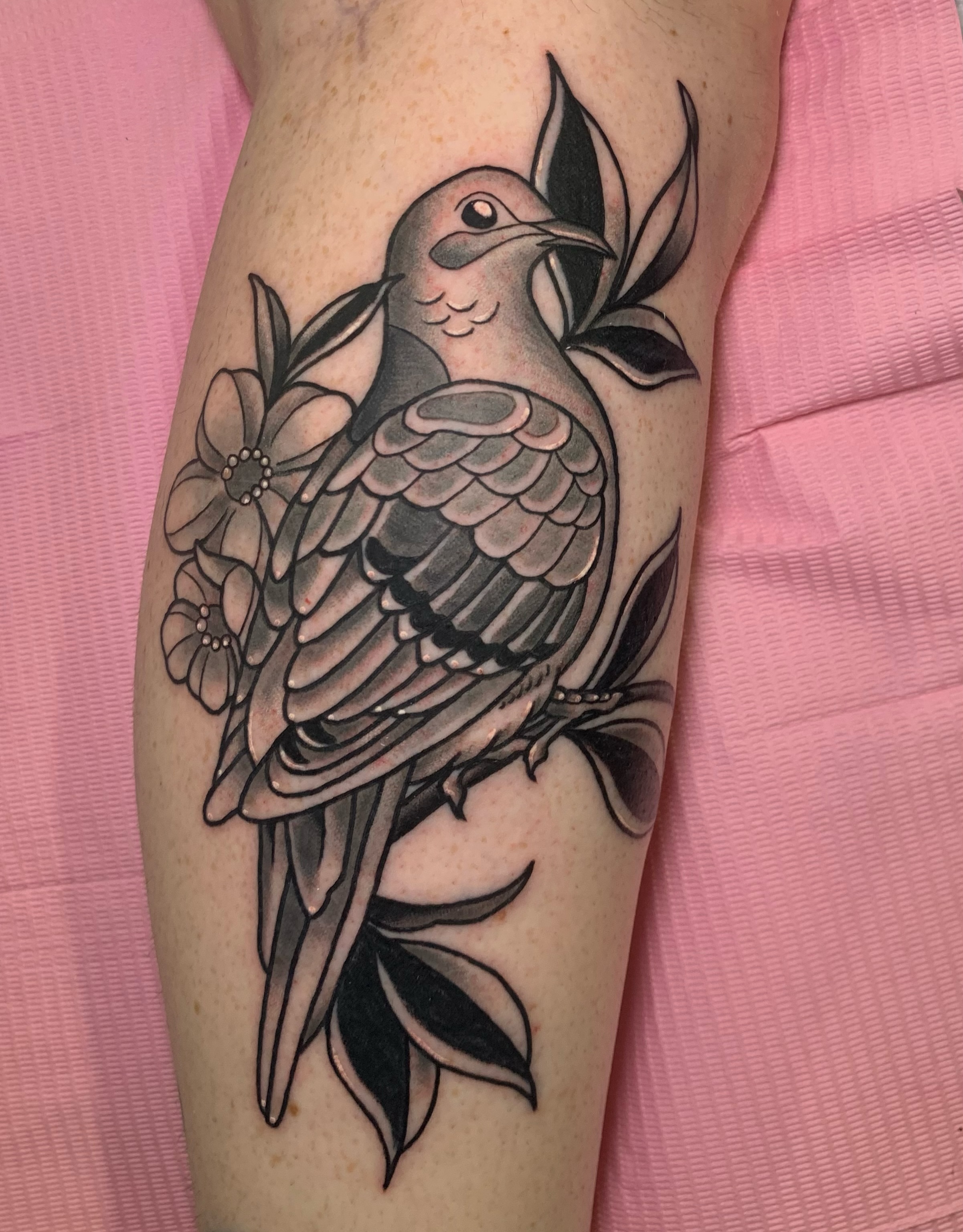 Dove and flowers black and grey tattoo on the forearm by Aubrianna Grisez