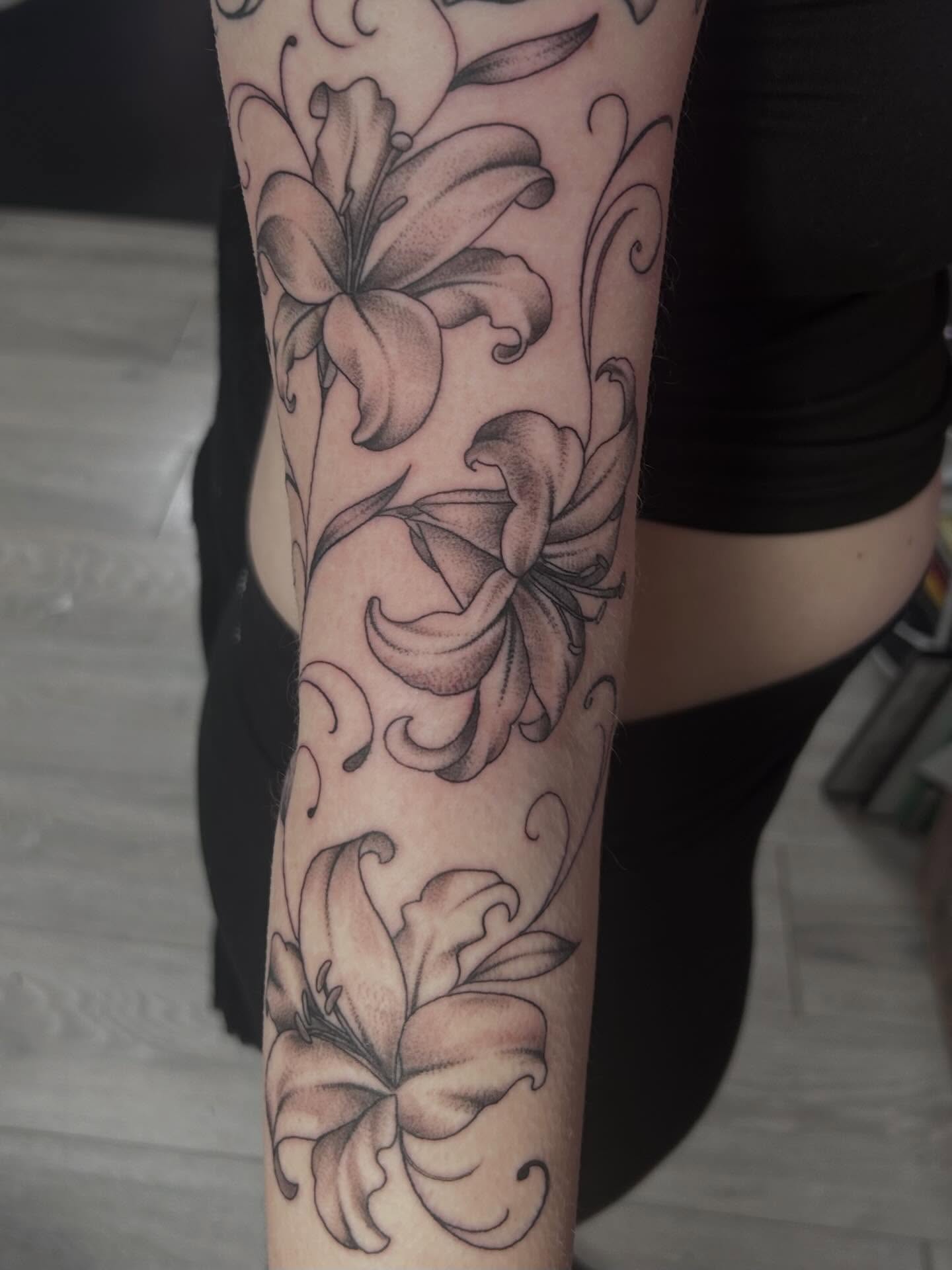 Lilies black and grey tattoo on the forearm by Red✨, Gansevoort, New York