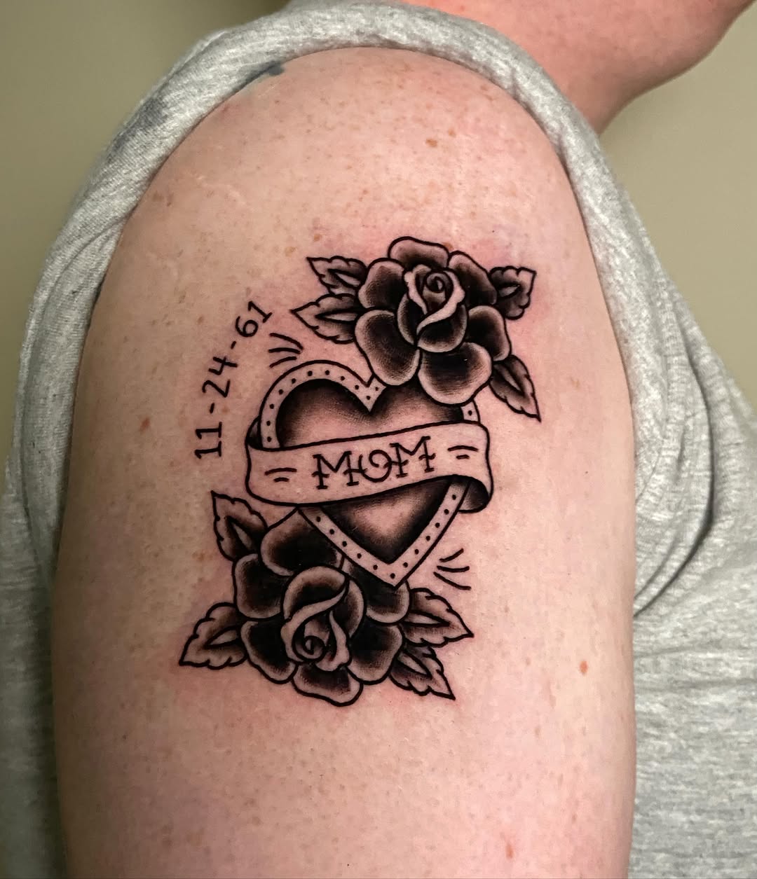 Heart with roses American traditional tattoo on the shoulder by Ezra Gonda