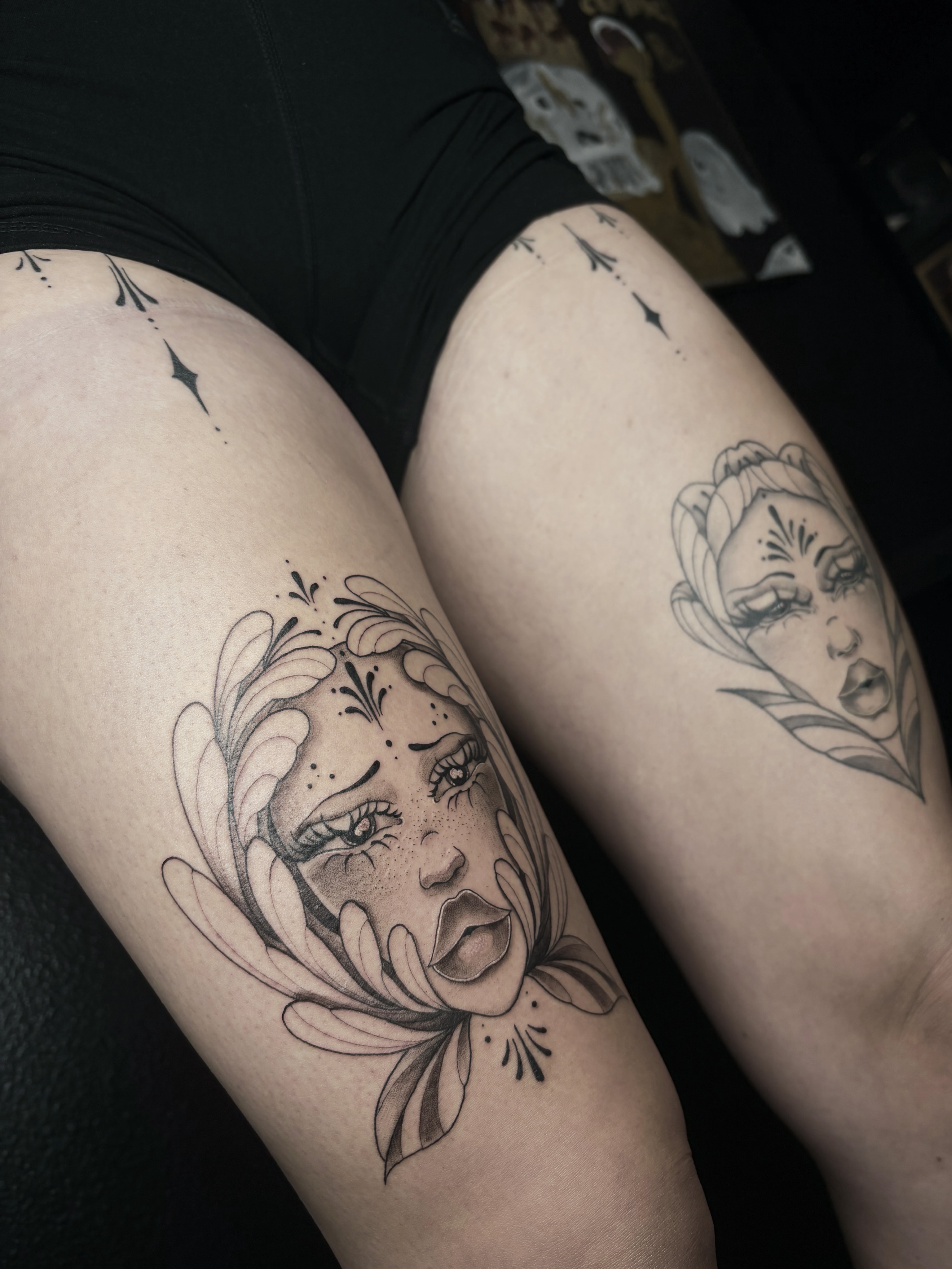 Woman's face with floral elements realism tattoo on the thigh by Fine Line Tattoo Artist