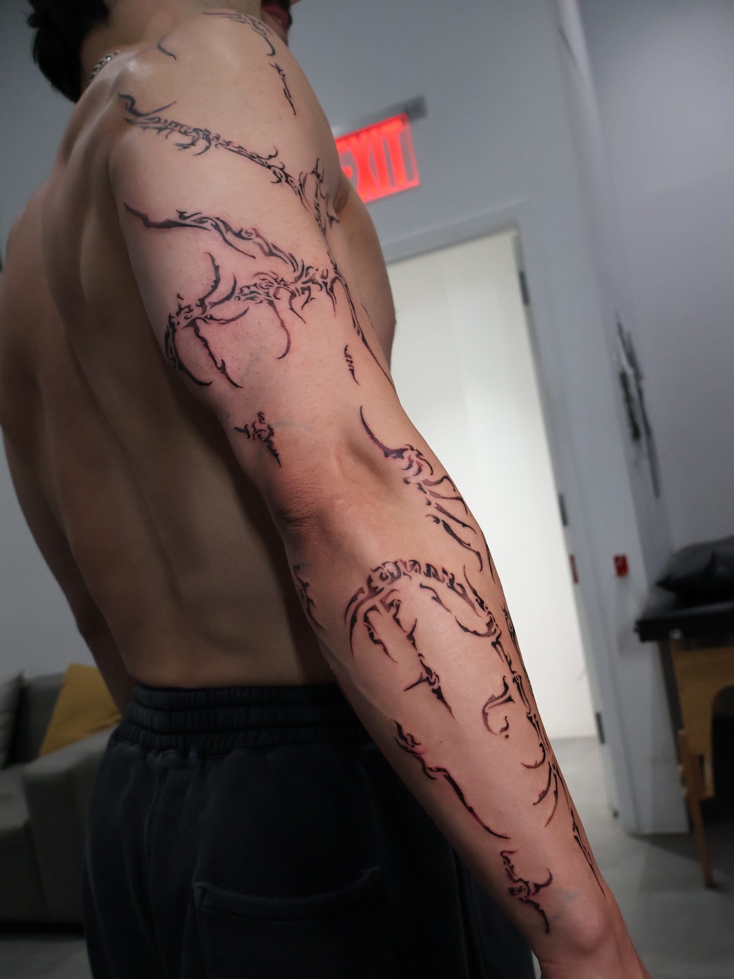 Abstract branches black and grey tattoo on the upper arm by Grace Zarmina Hessam