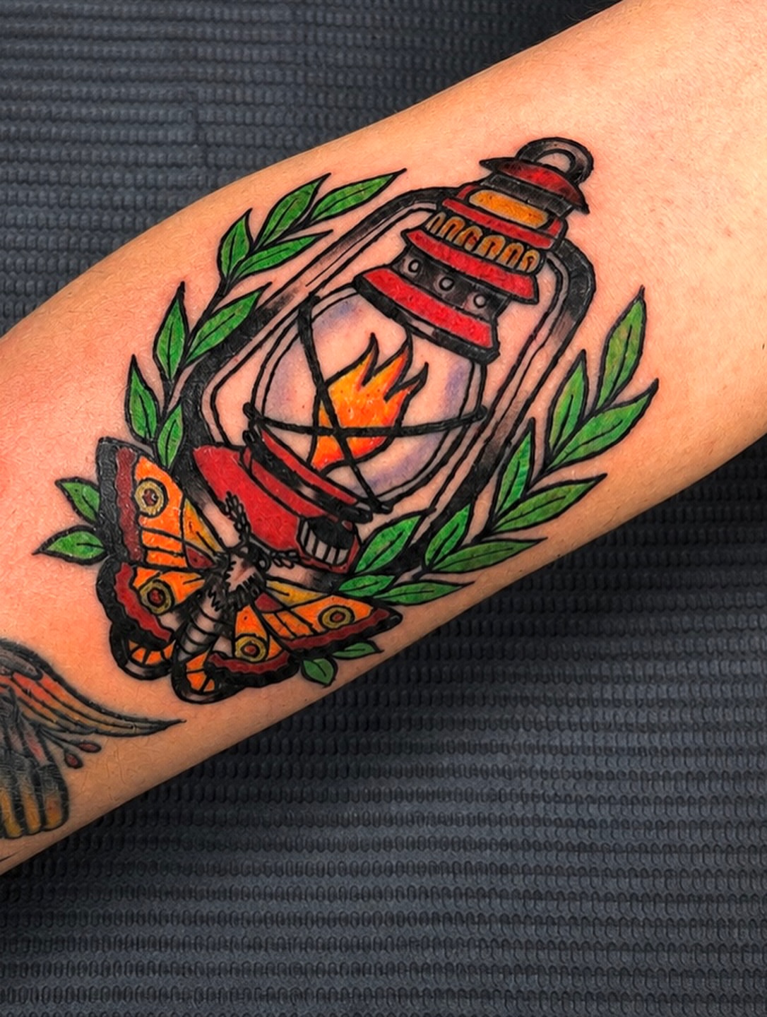 Lantern and butterfly American traditional tattoo on the forearm by Evan Intveld