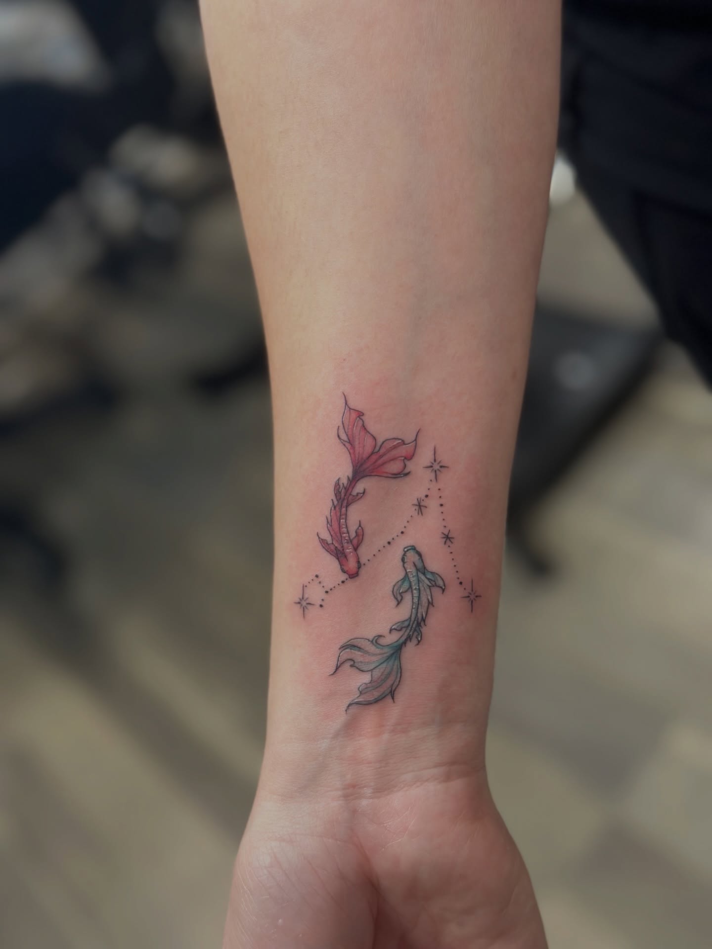 Koi fish and stars dotwork tattoo on the forearm by Sabrina, Harrison, New Jersey