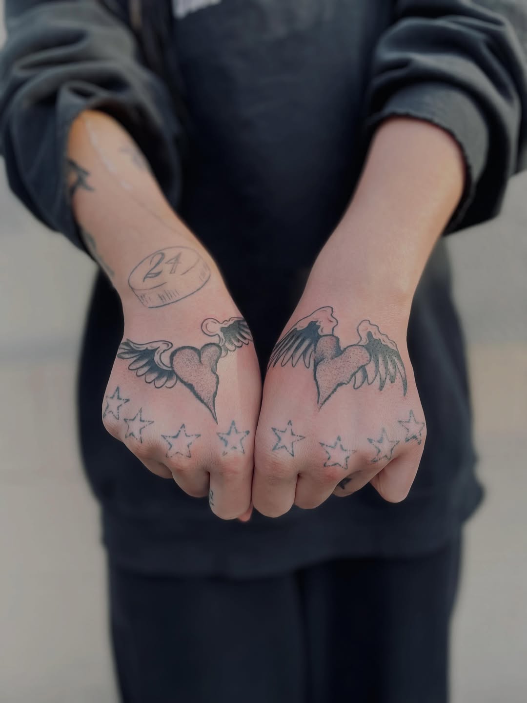 Winged hearts and stars lettering tattoo on the hand by Christien Xavier Alba, Salt Lake City, Utah