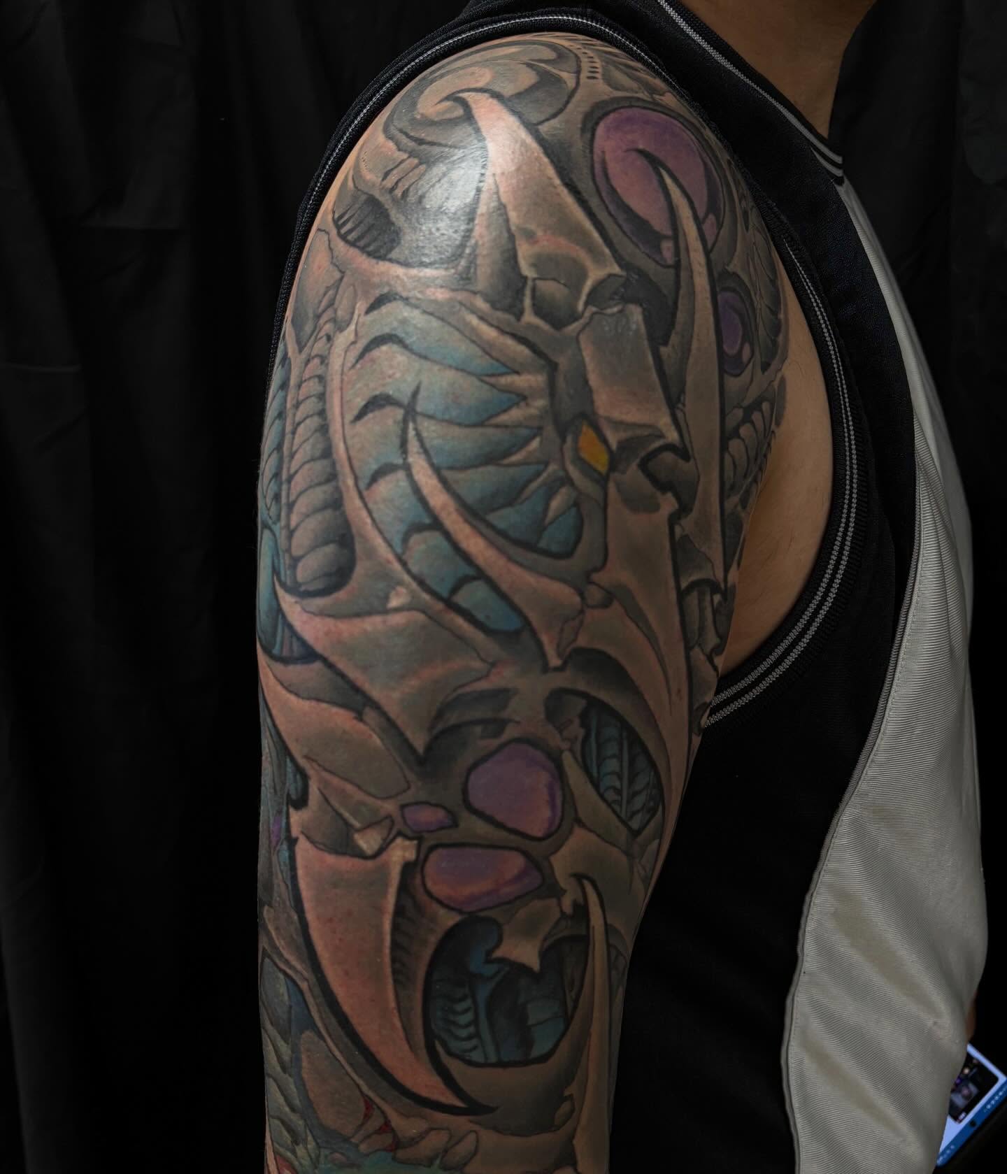 Cyborg head geometric tattoo on the upper arm by Rene Chavira