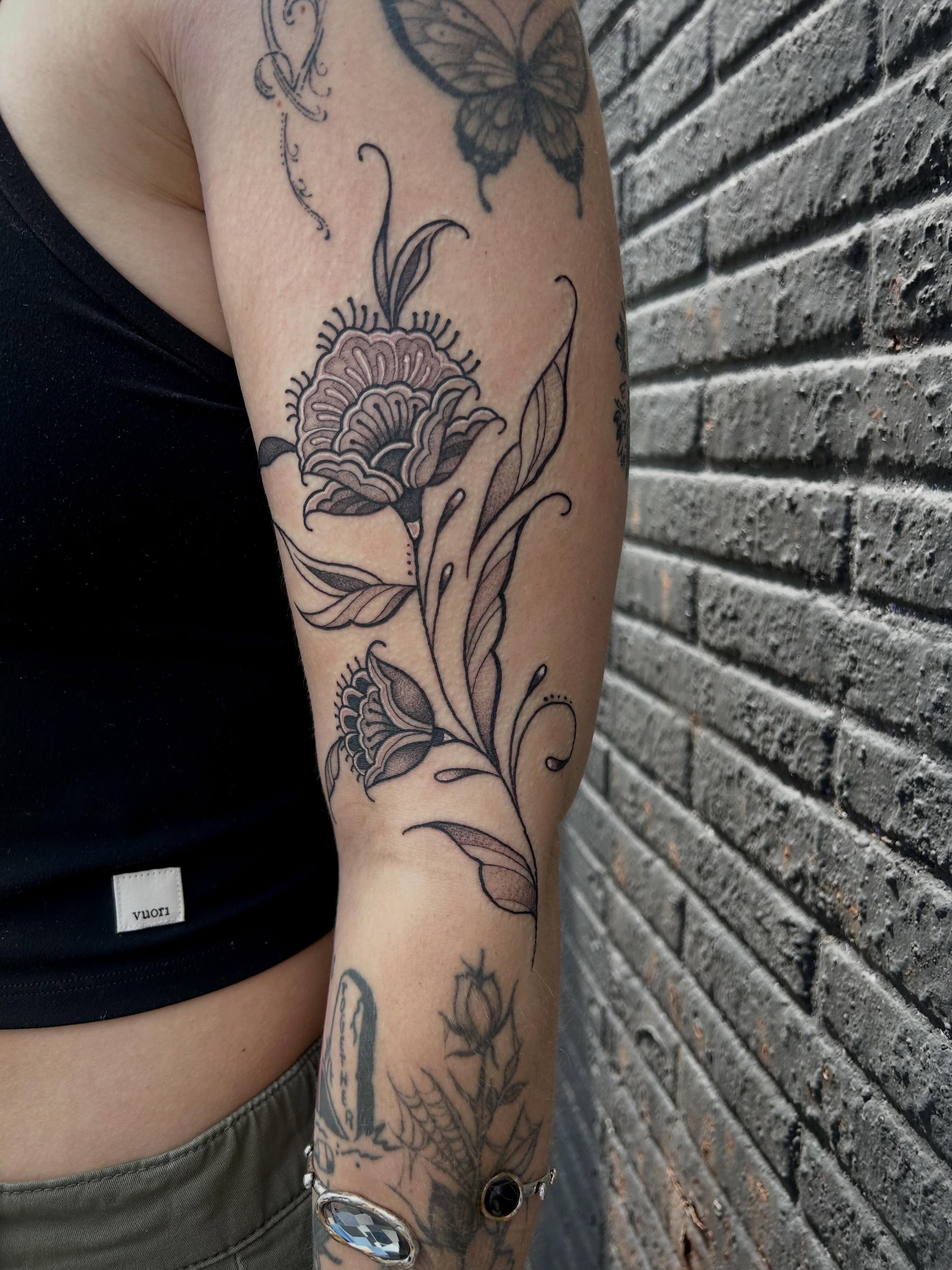 Floral arrangement black and grey tattoo on the forearm by Bria🩸