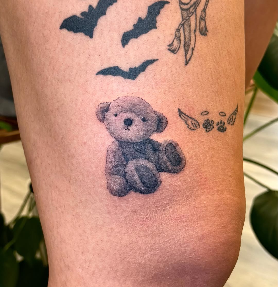 Teddy bear black and grey tattoo on the forearm by Xin Huang