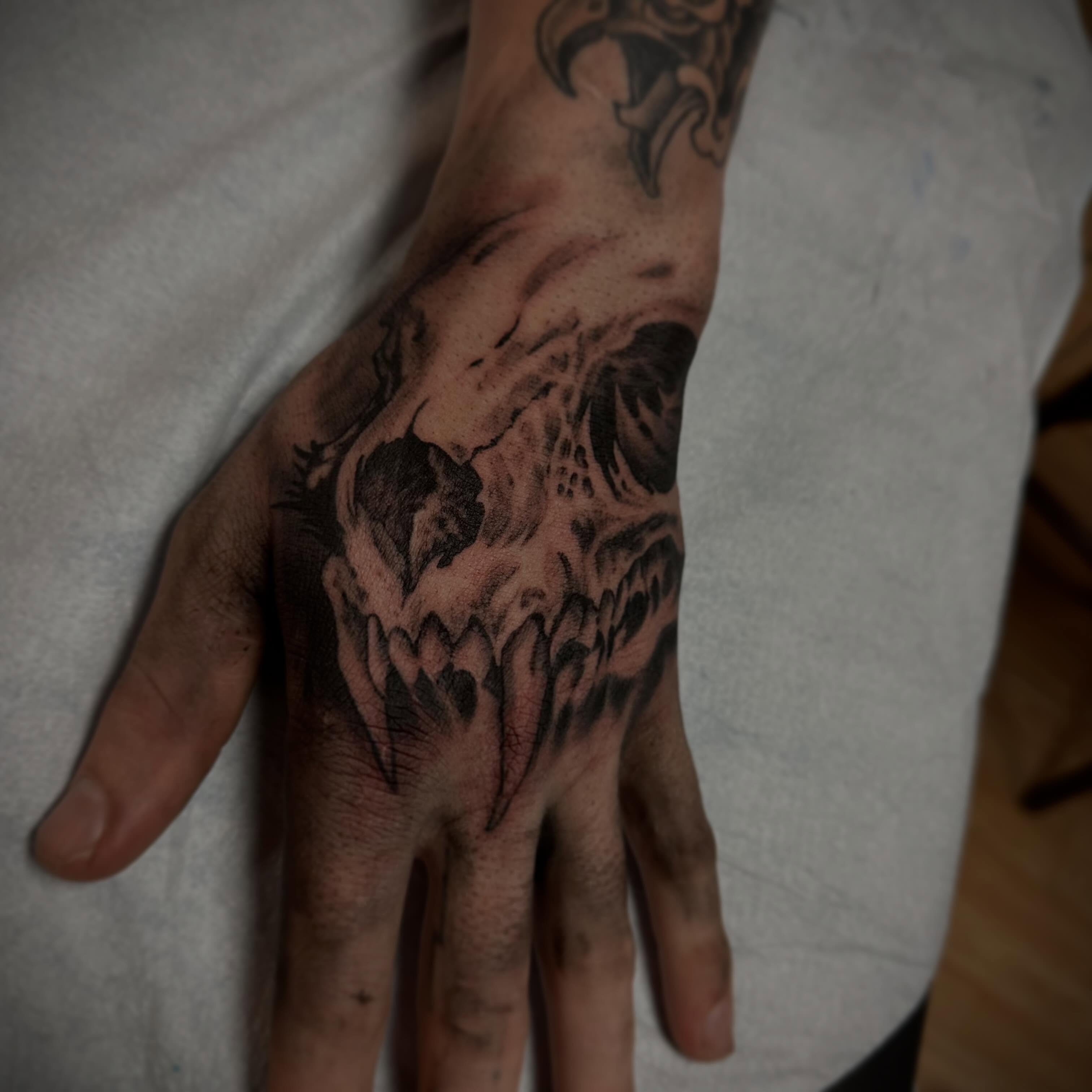 Skull black and grey tattoo on the hand by Sebastian Livingston
