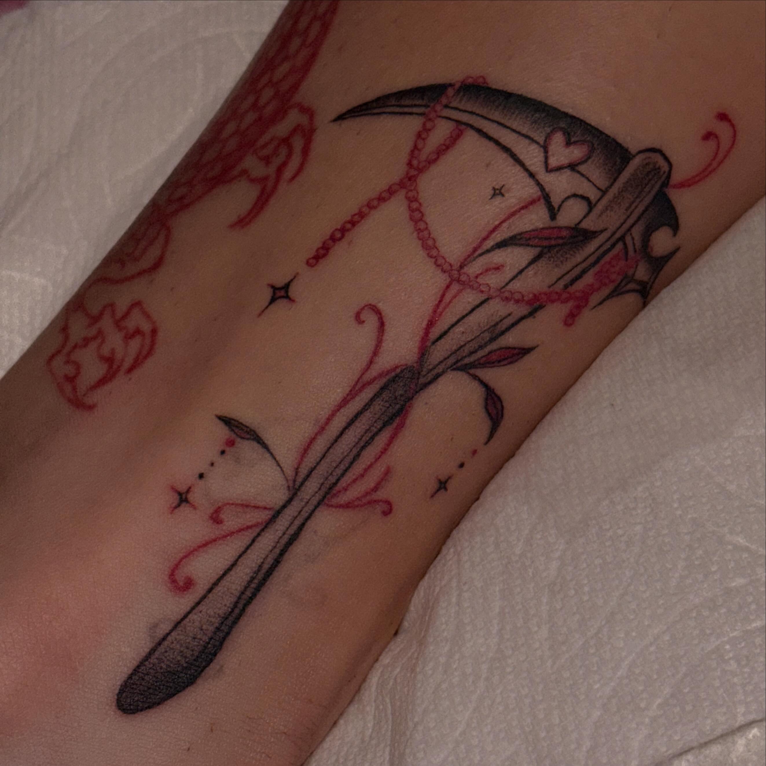Scythe and string American traditional tattoo on the forearm by Tattoomobile