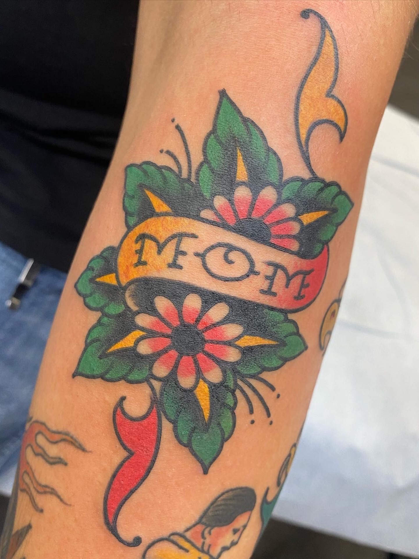 Flower and banner American traditional tattoo on the forearm by Ben Karnofsky