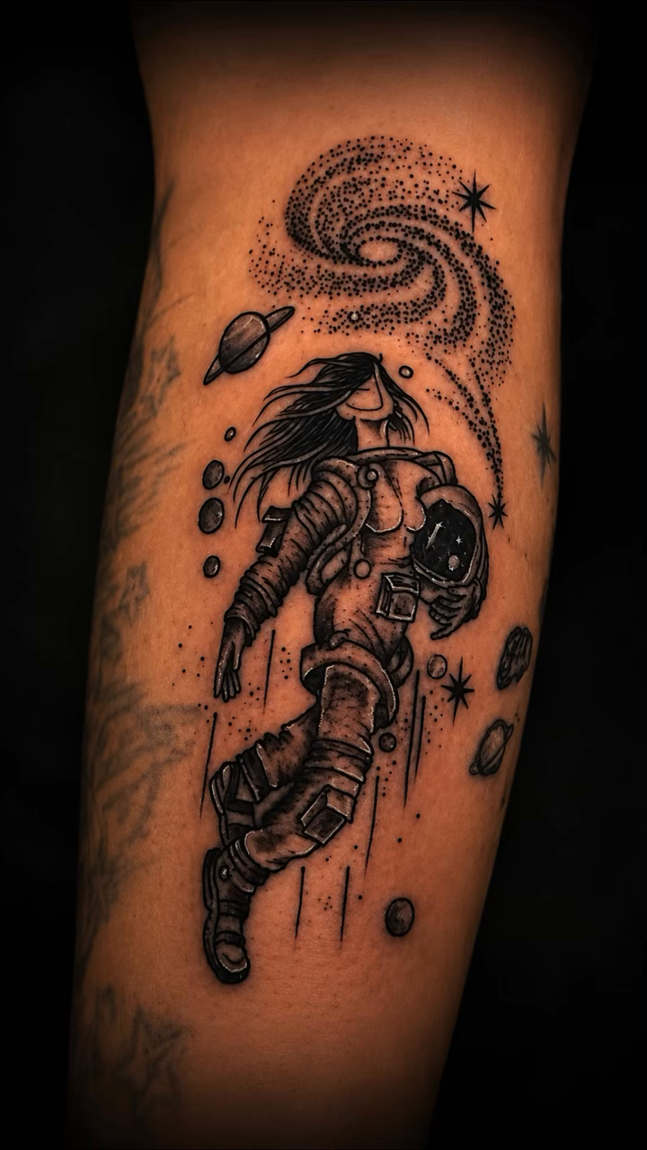 Astronaut in space surrealism tattoo on the forearm by Christhian King