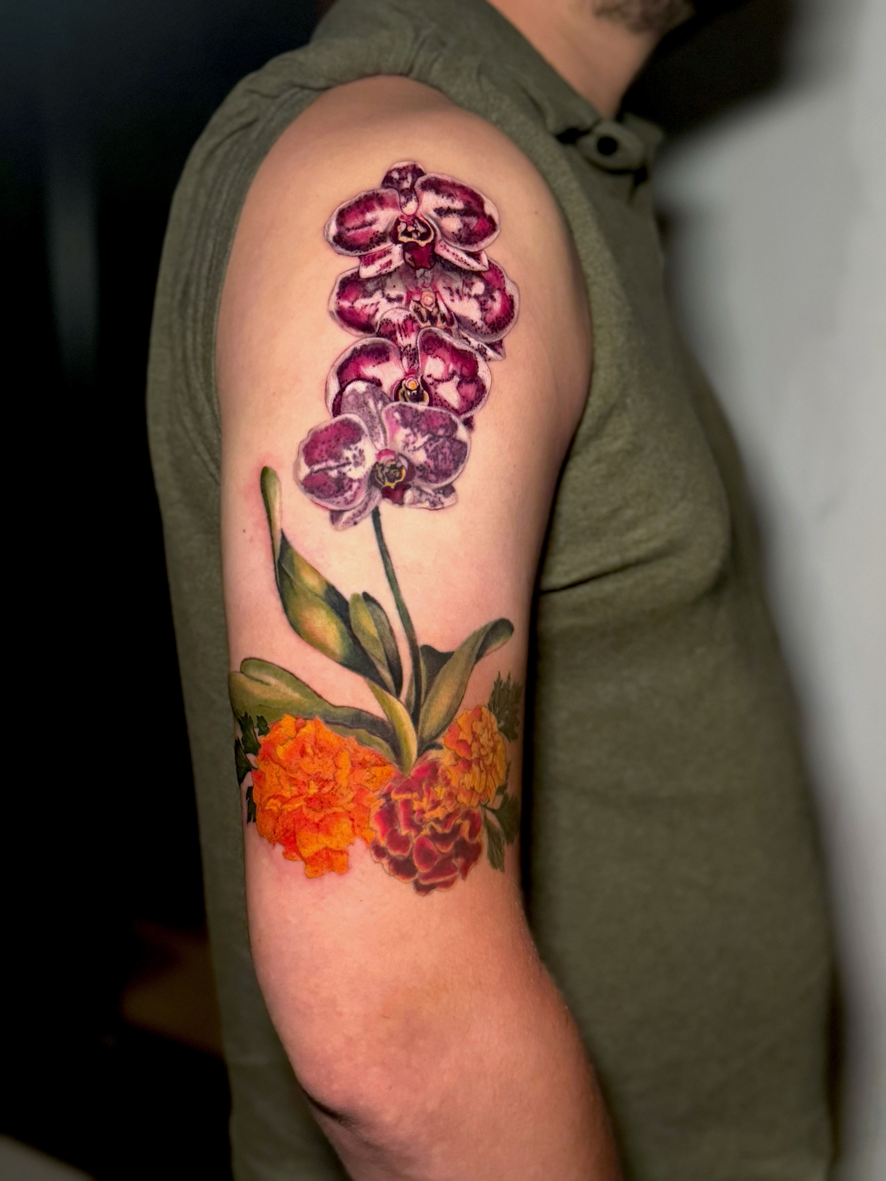 Orchids and marigolds realism tattoo on the forearm by 𝕀𝕣𝕚𝕤 𝔸𝕣𝕖𝕝𝕝𝕒𝕟𝕠