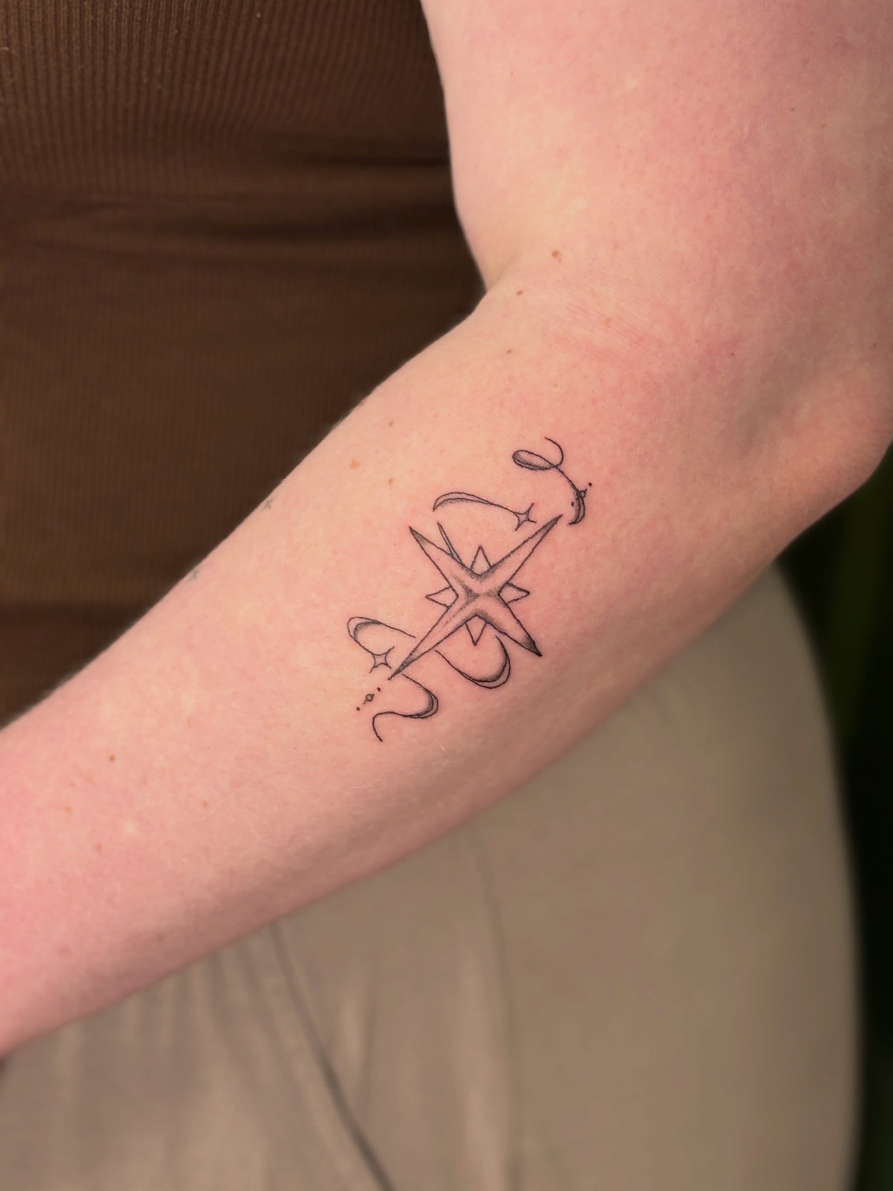 Compass and stars fine line tattoo on the forearm by Maddie