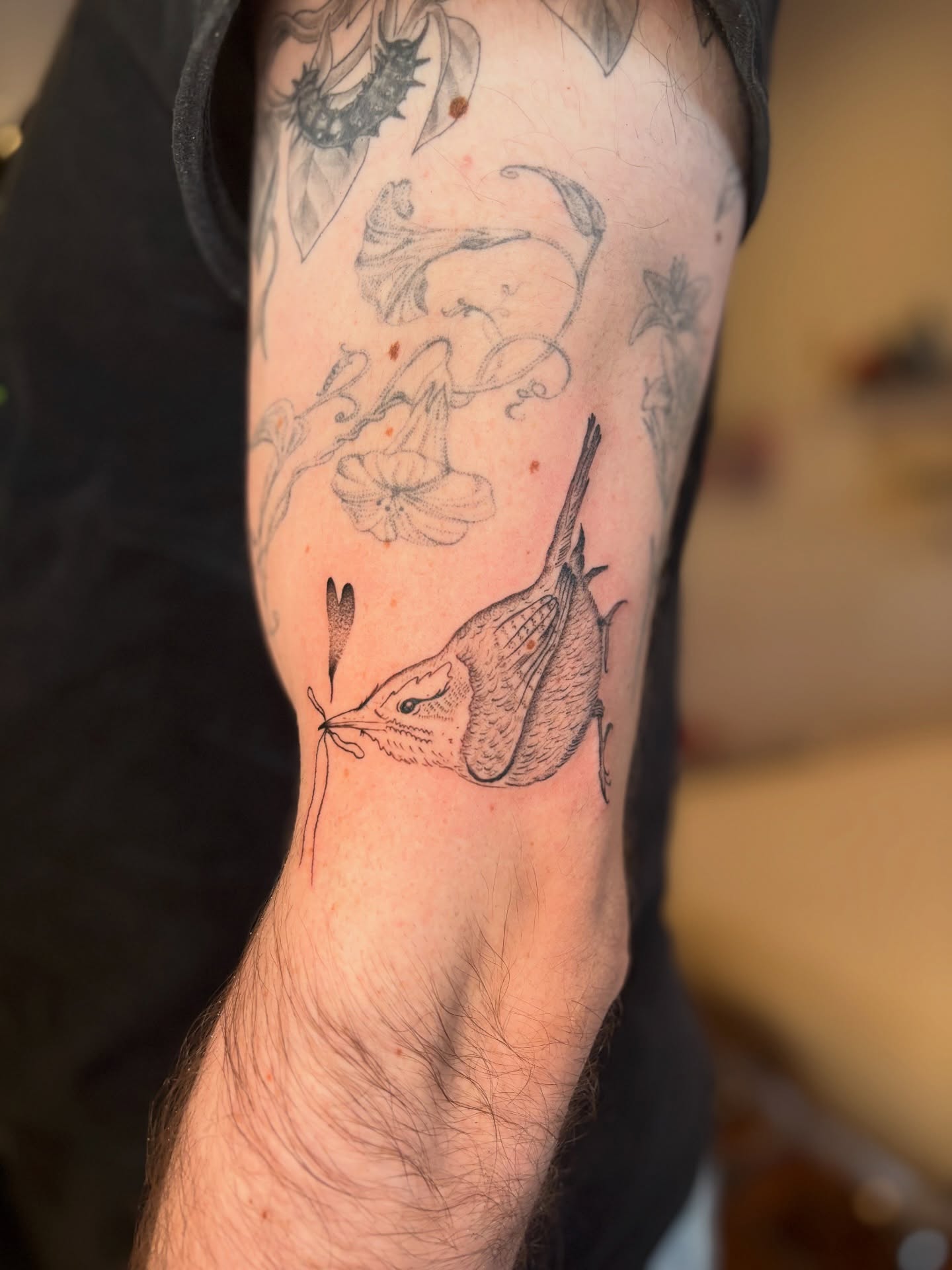 Bird and flowers black and grey tattoo on the forearm by carla sofia