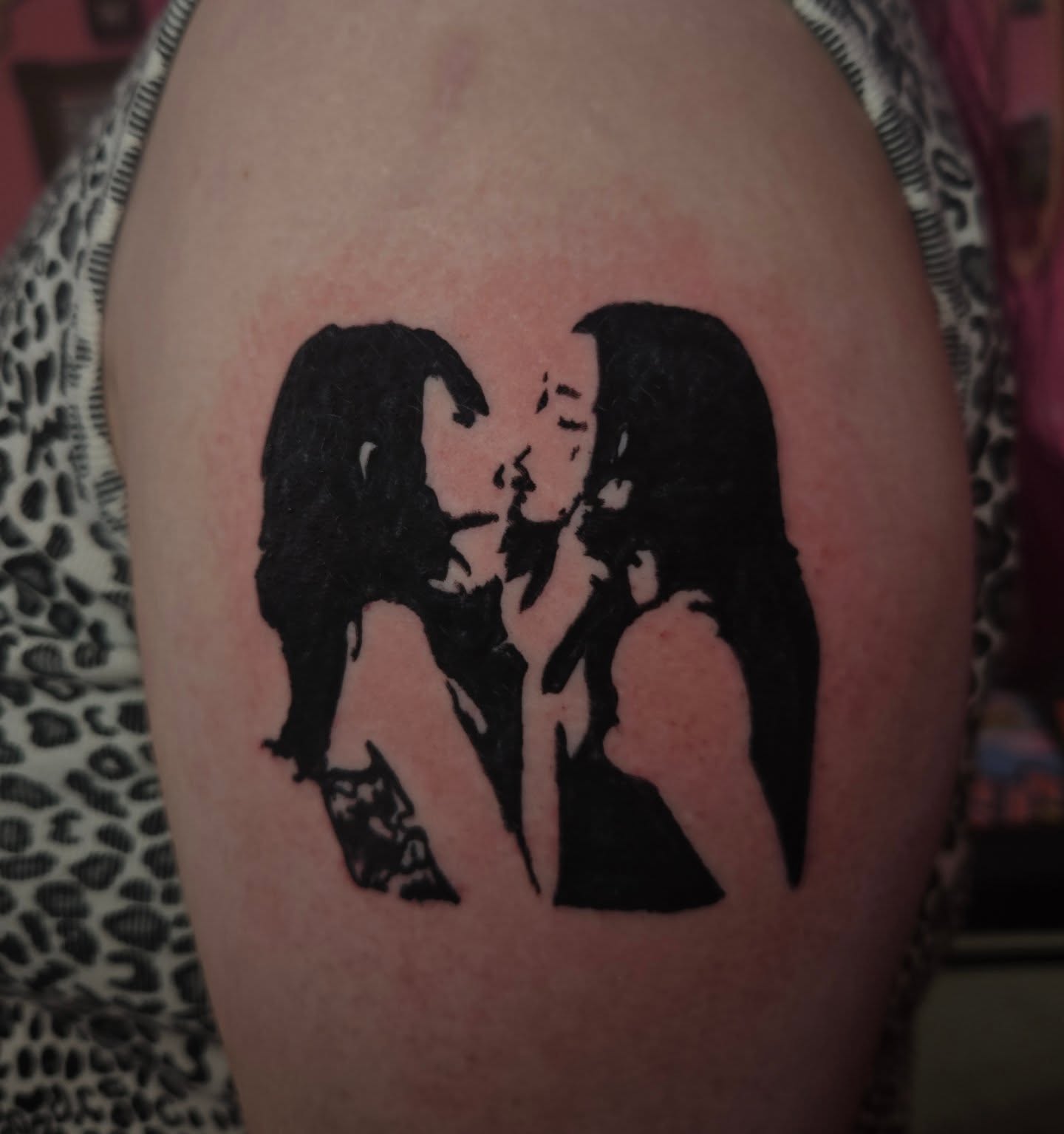 Kissing couple black and grey tattoo on the shoulder by Lane