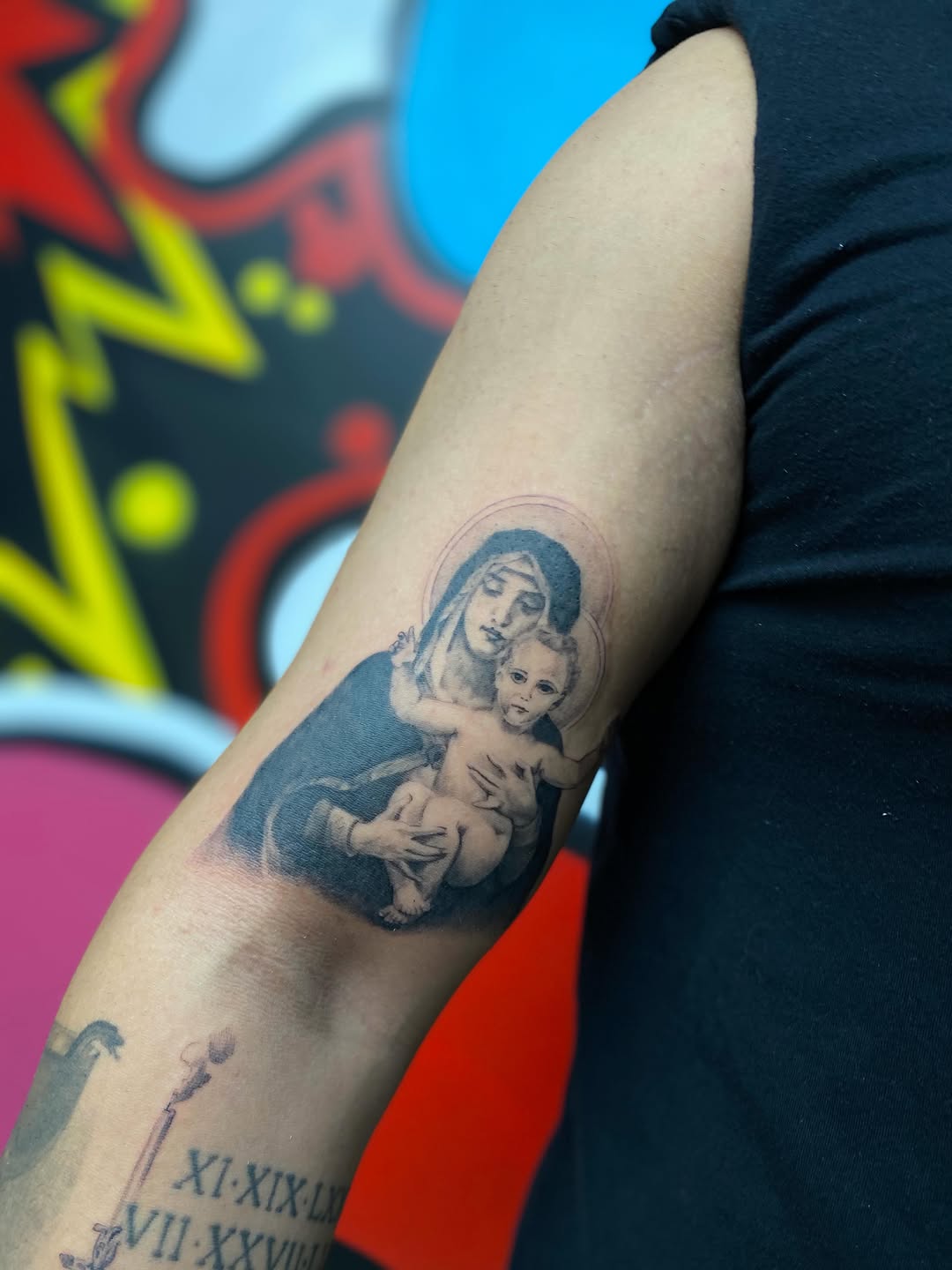 Virgin Mary holding baby Jesus Chicano tattoo on the forearm by Antonio