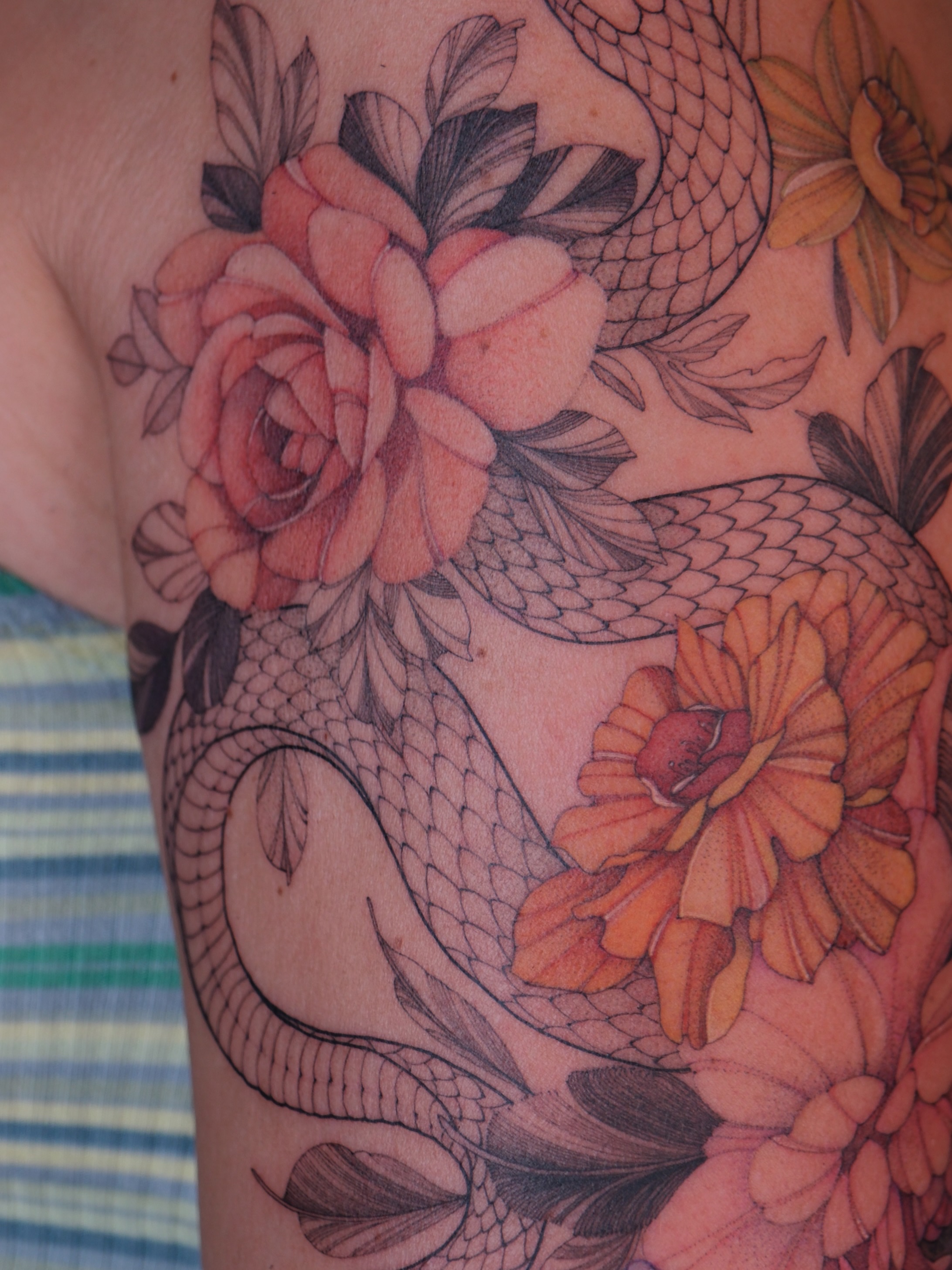 Snake and flowers realism tattoo on the shoulder by Flower Tattoo Sf