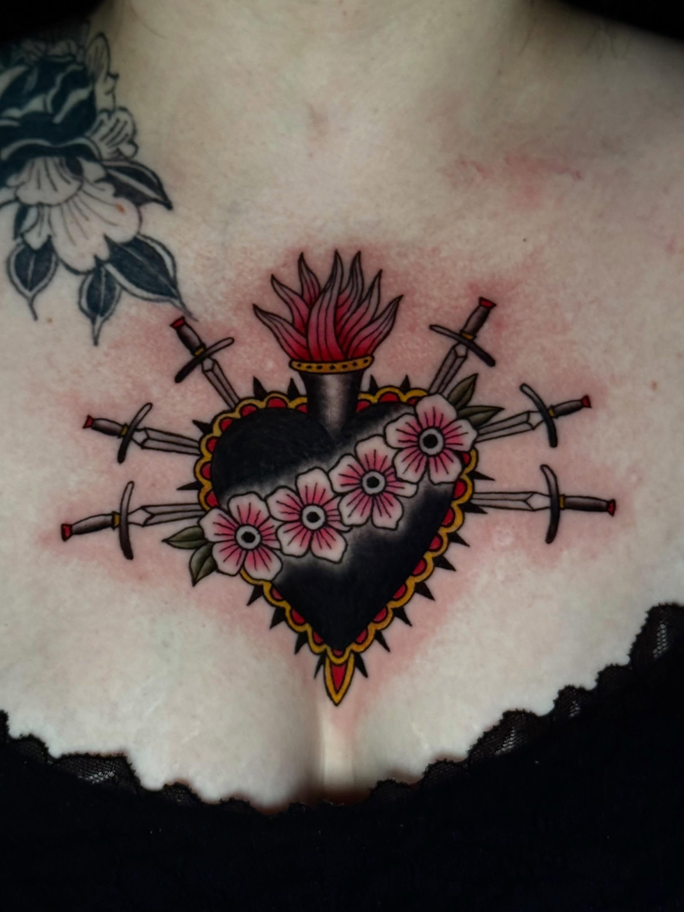 Heart with swords American traditional tattoo on the chest by CAT