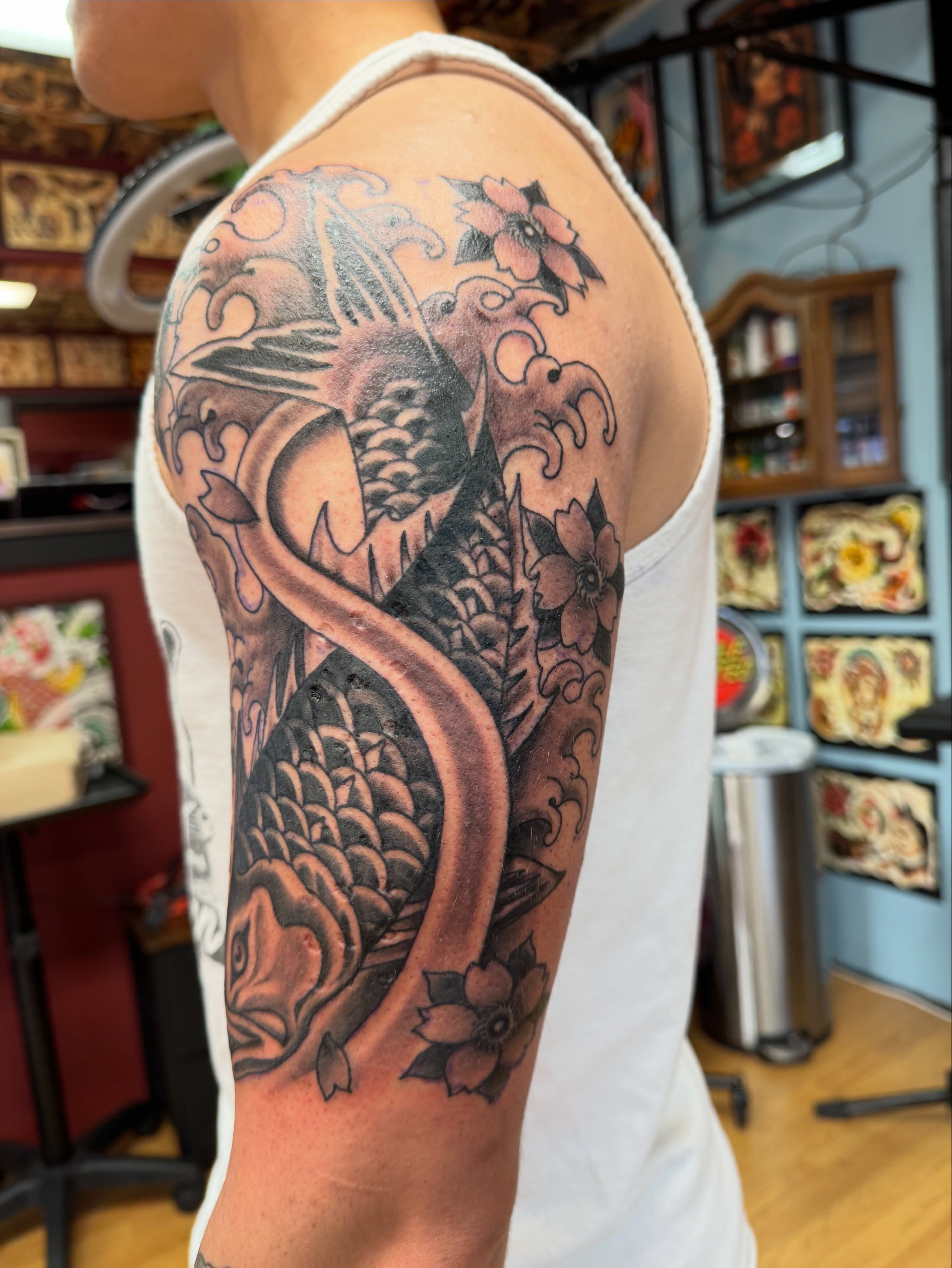Koi fish and flowers japanese irezumi tattoo on the upper arm by Brian Hutflies