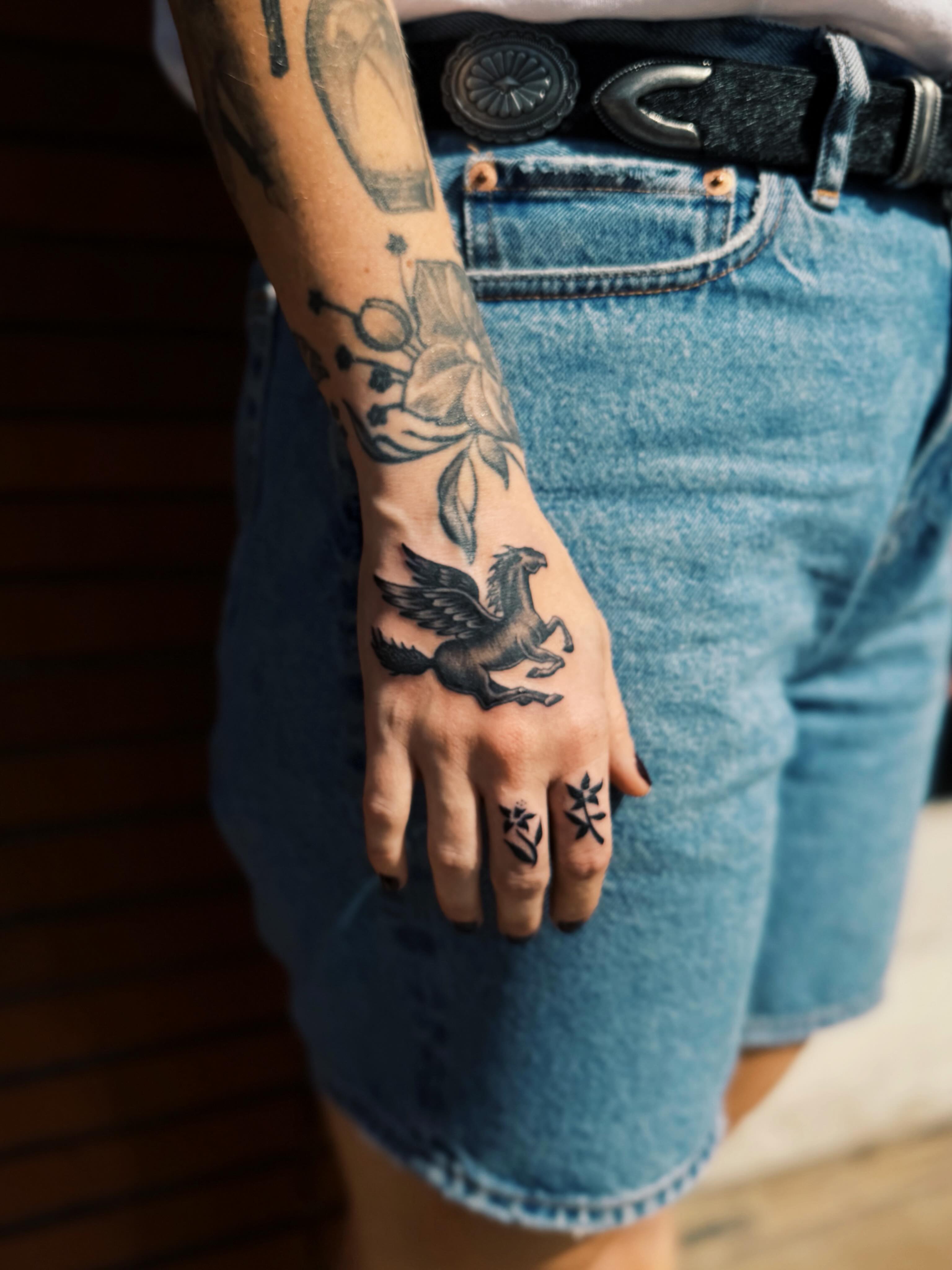 Pegasus and floral black and grey tattoo on the forearm by @amandahowtattoo