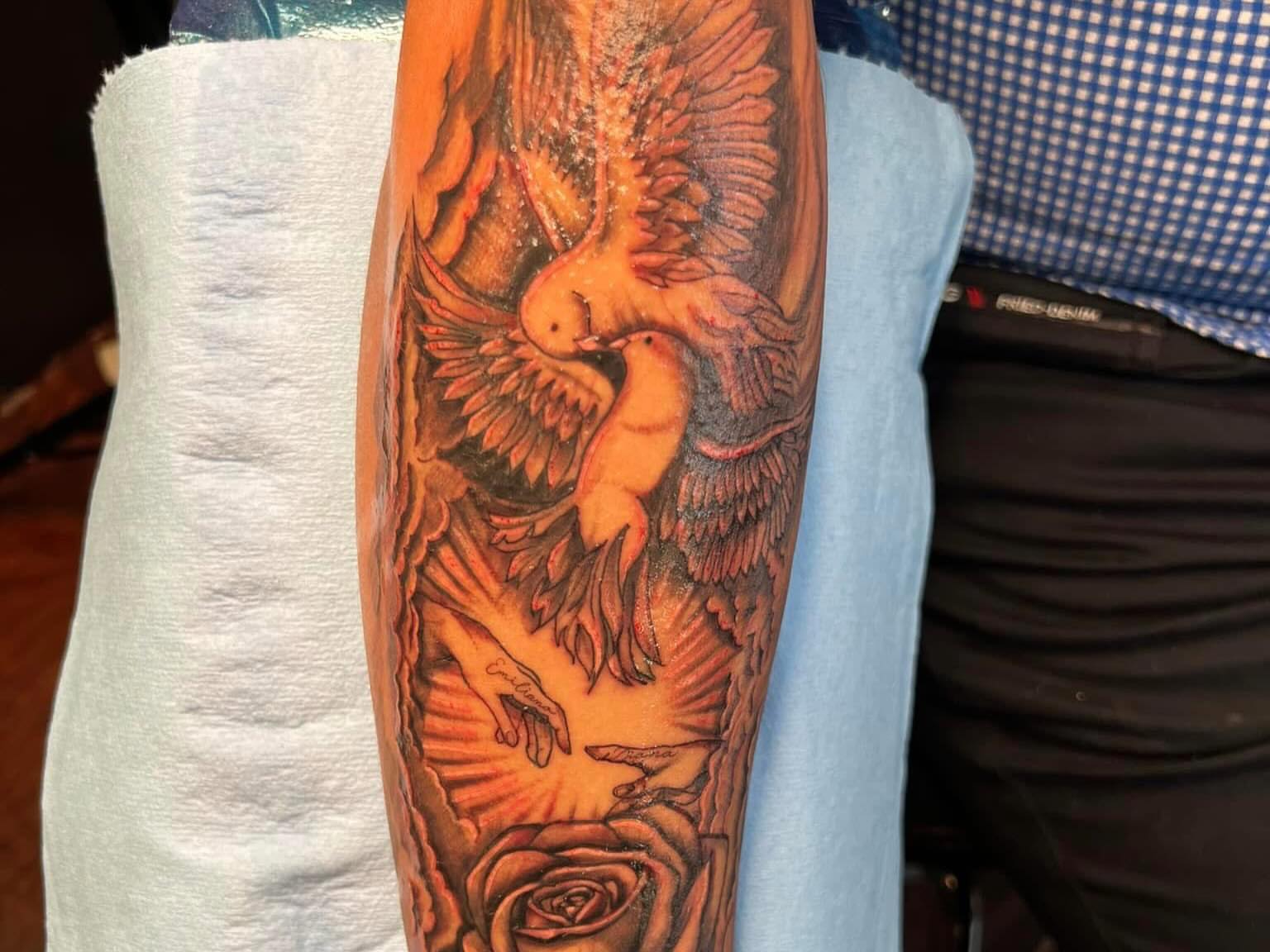 Doves and roses realism tattoo on the forearm by Tattoomobile
