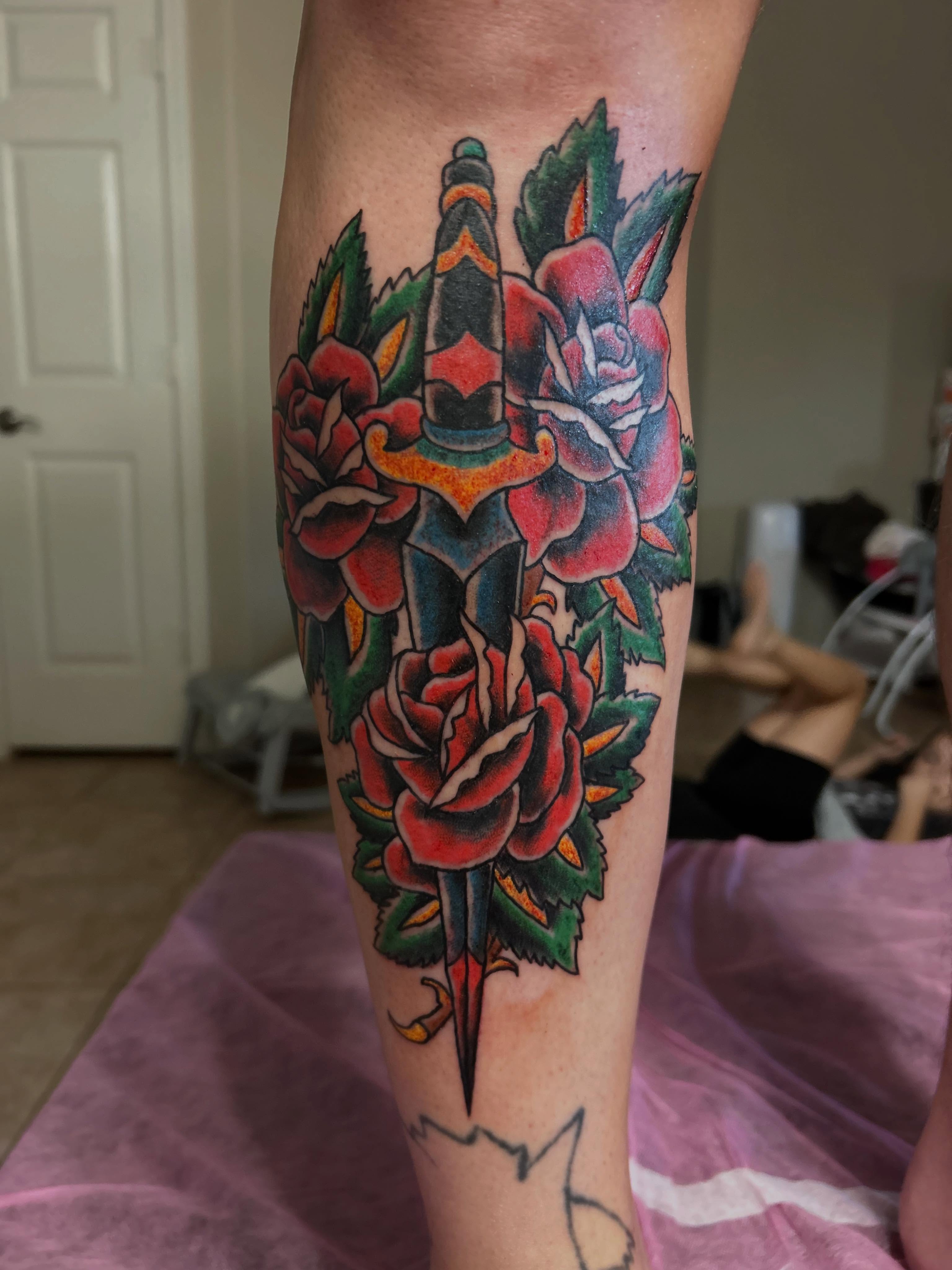 Roses and dagger American traditional tattoo on the forearm by Stogie Tony