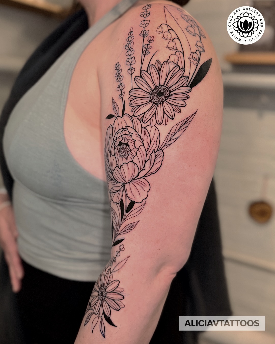 Floral bouquet black and grey tattoo on the upper arm by Alicia Vasquez