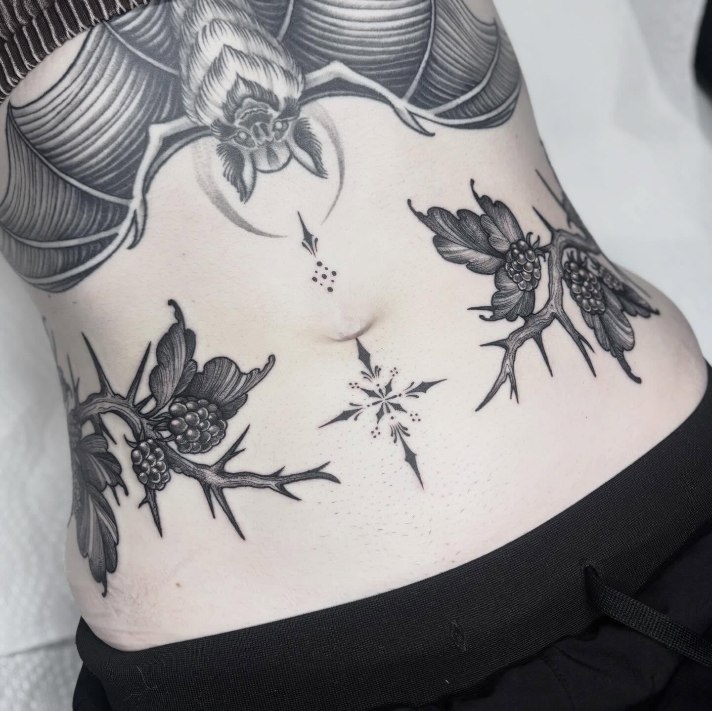 Thorns and flowers dotwork tattoo on the torso by Cincinnati