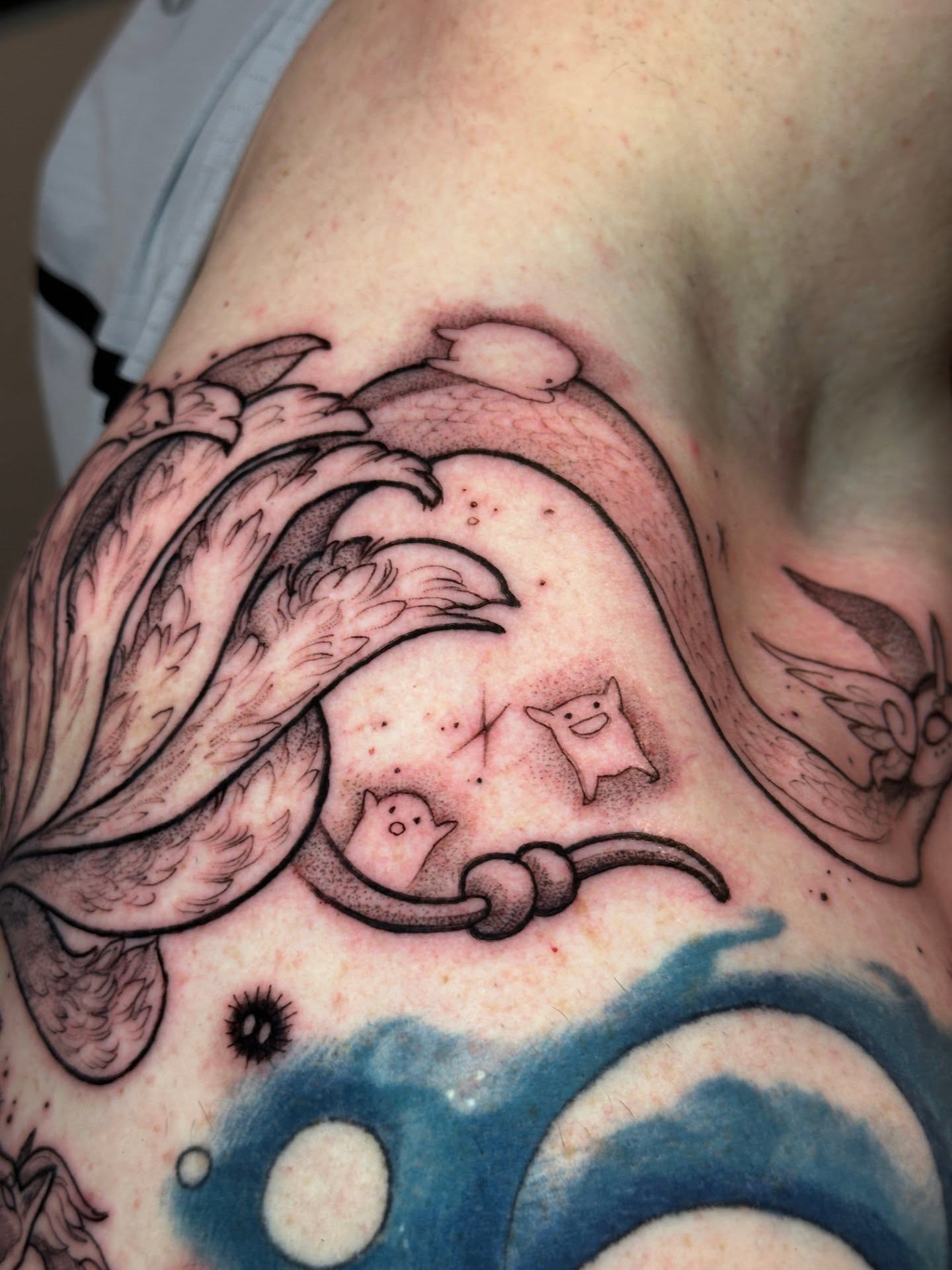 Wave and ghost black and grey tattoo on the shoulder by Sasha Wren