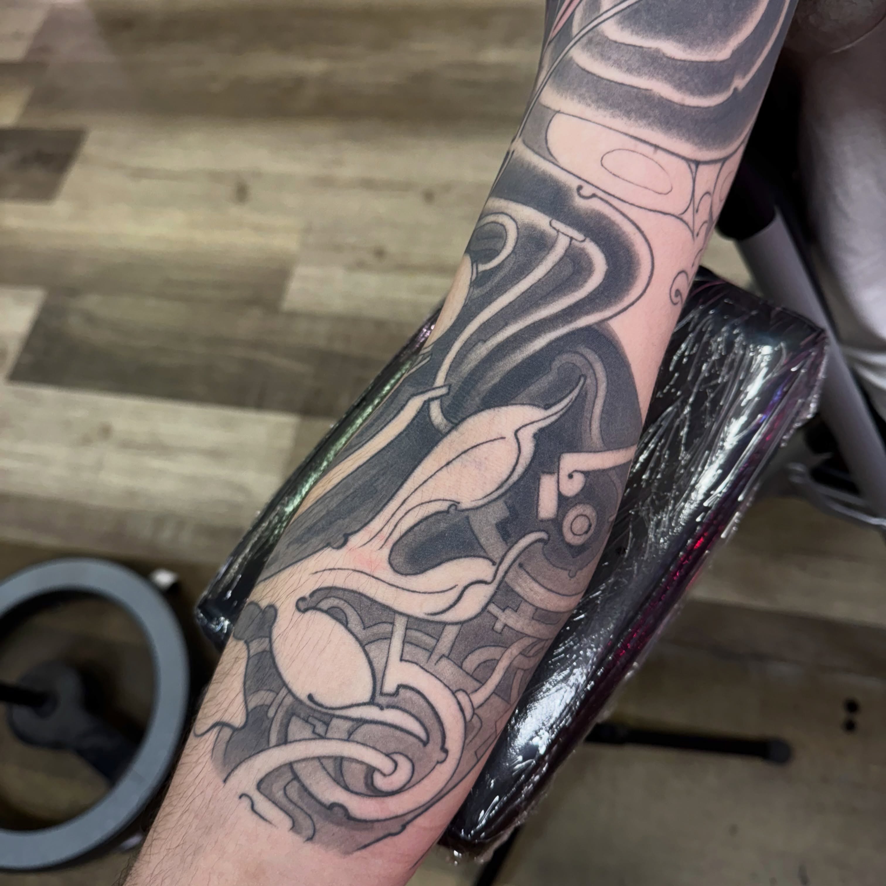 Abstract design black and grey tattoo on the forearm by Chris Orta