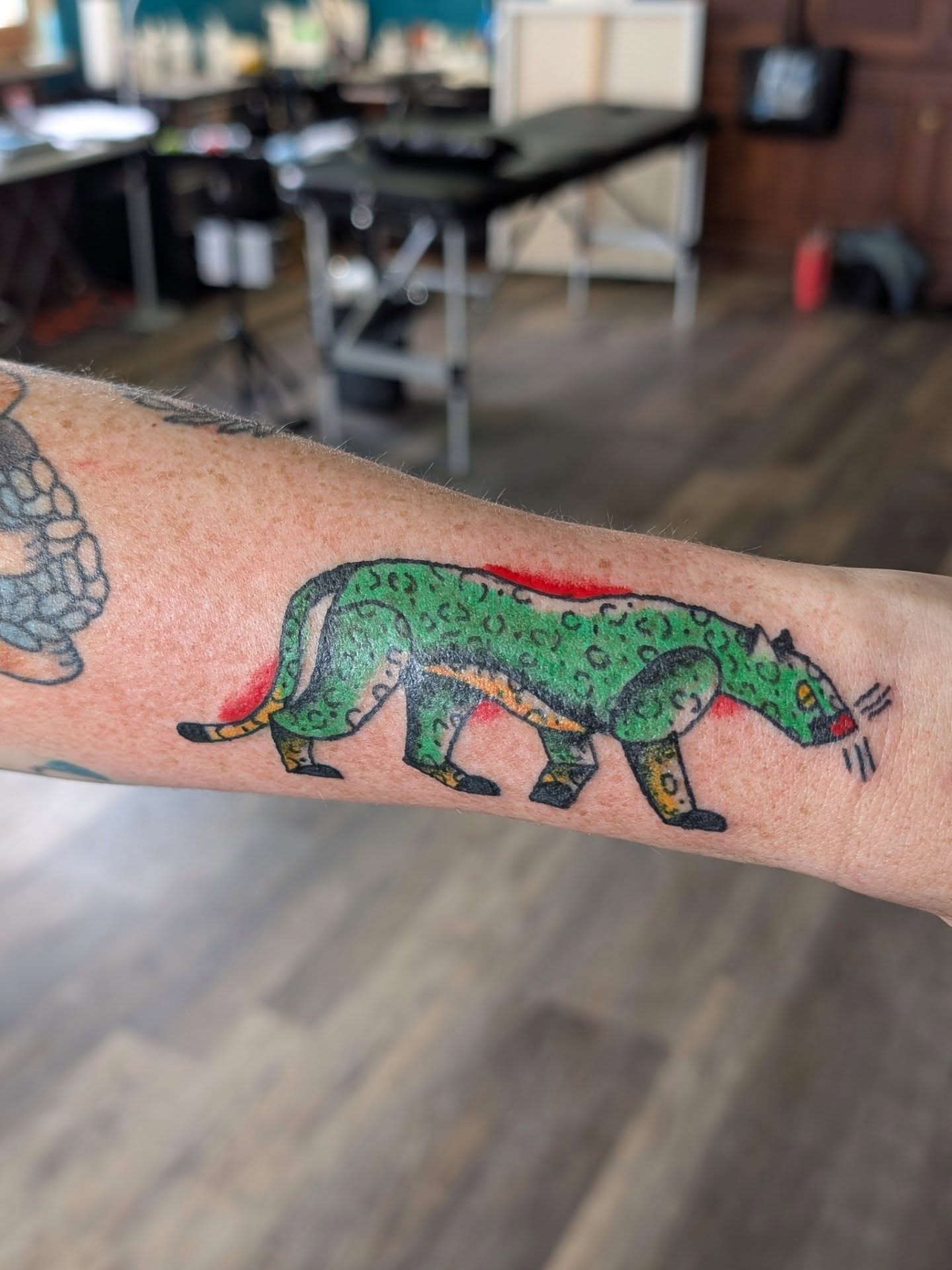 Green jaguar American traditional tattoo on the forearm by Jon Sedor