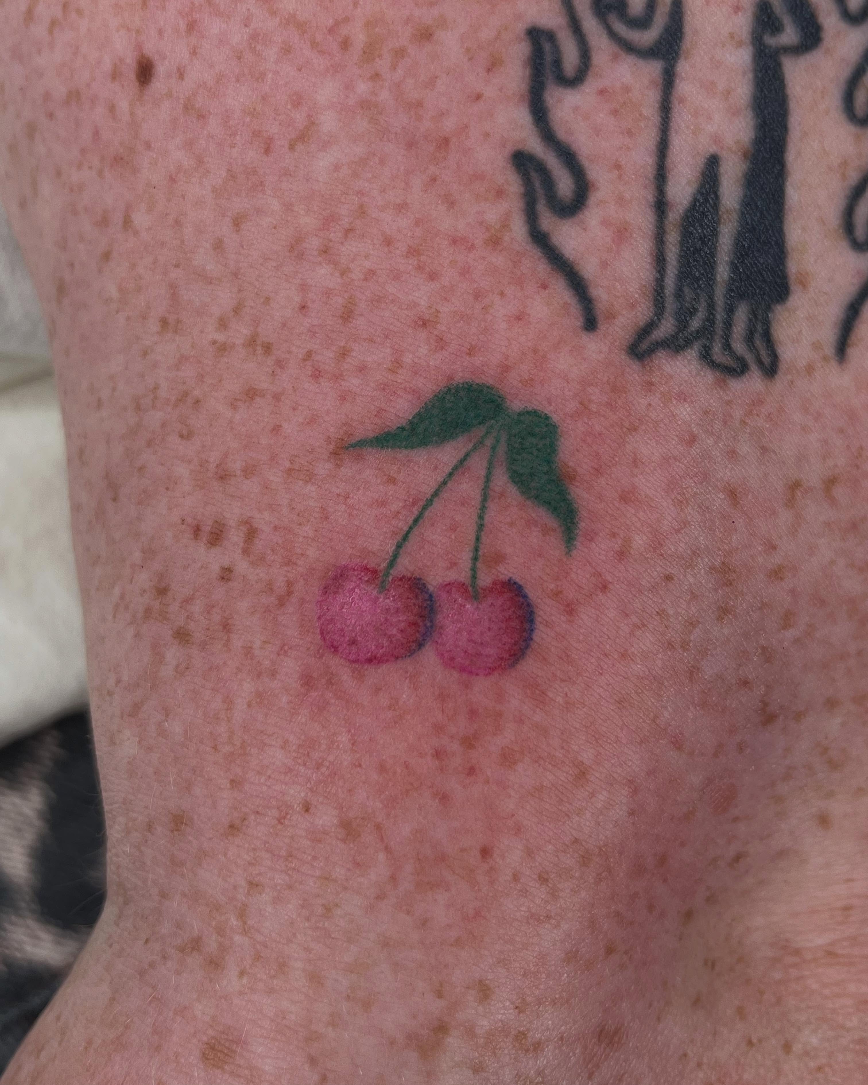 Cherries watercolor tattoo on the forearm by Jenna