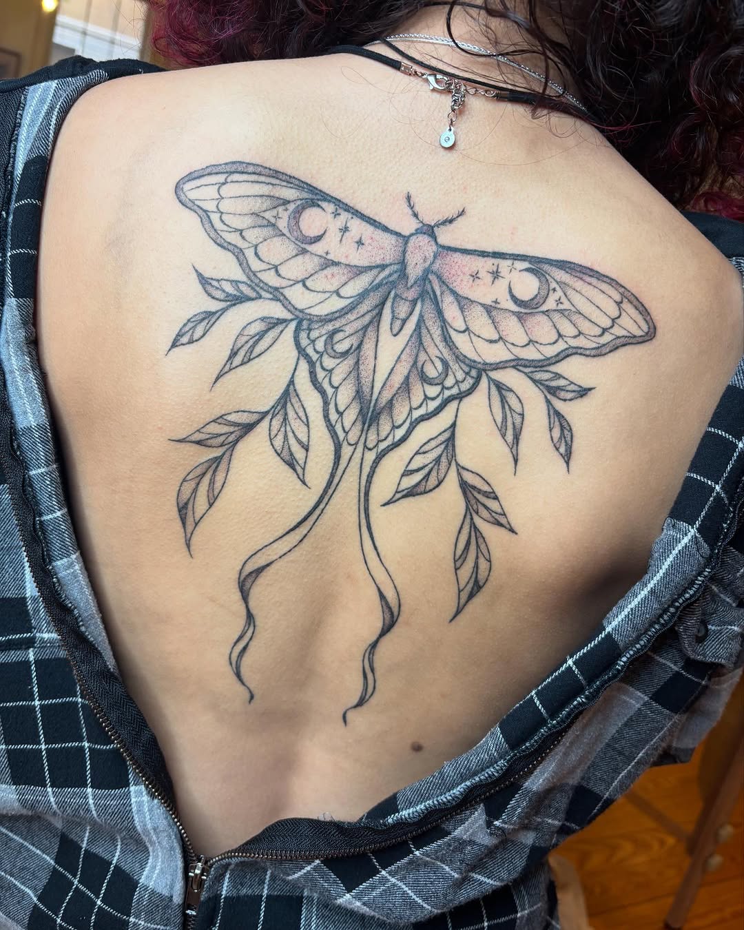 Moth with moons and stars fine line tattoo on the back by madison, Cincinnati