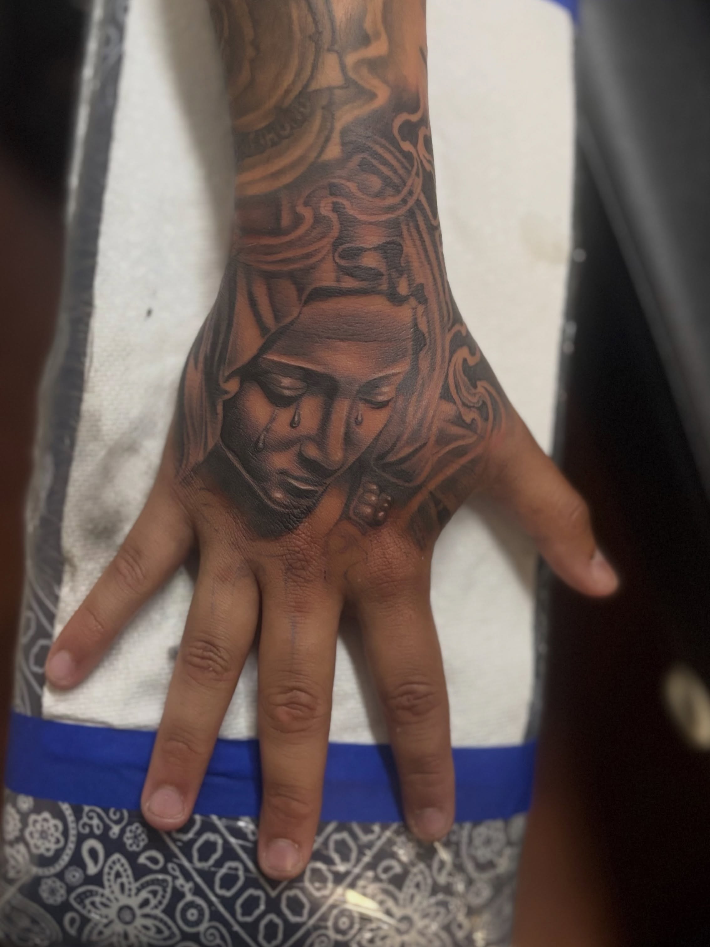 Woman's face realism tattoo on the hand by @tattoosbyadrian