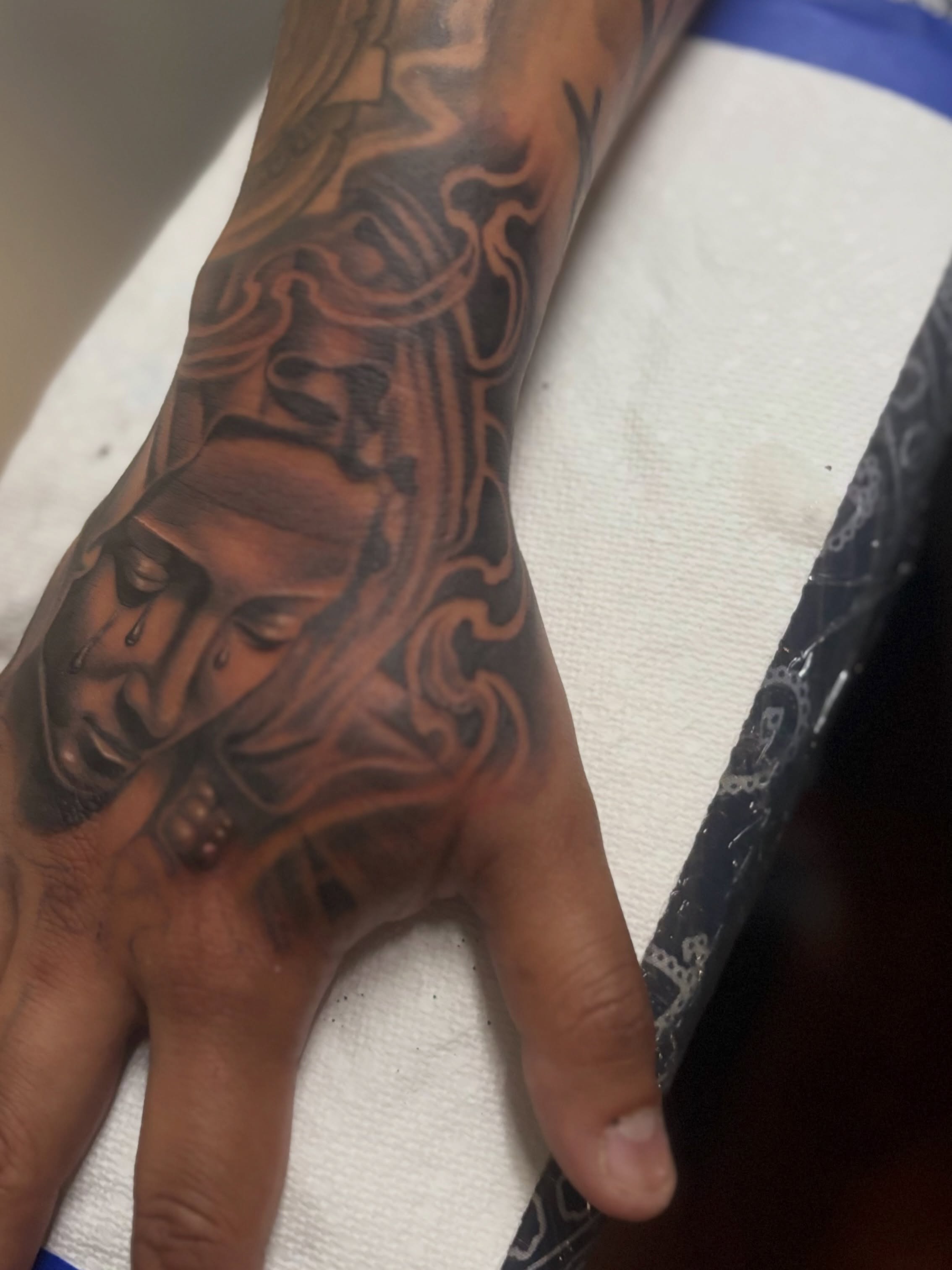 Man's face realism tattoo on the hand by @tattoosbyadrian