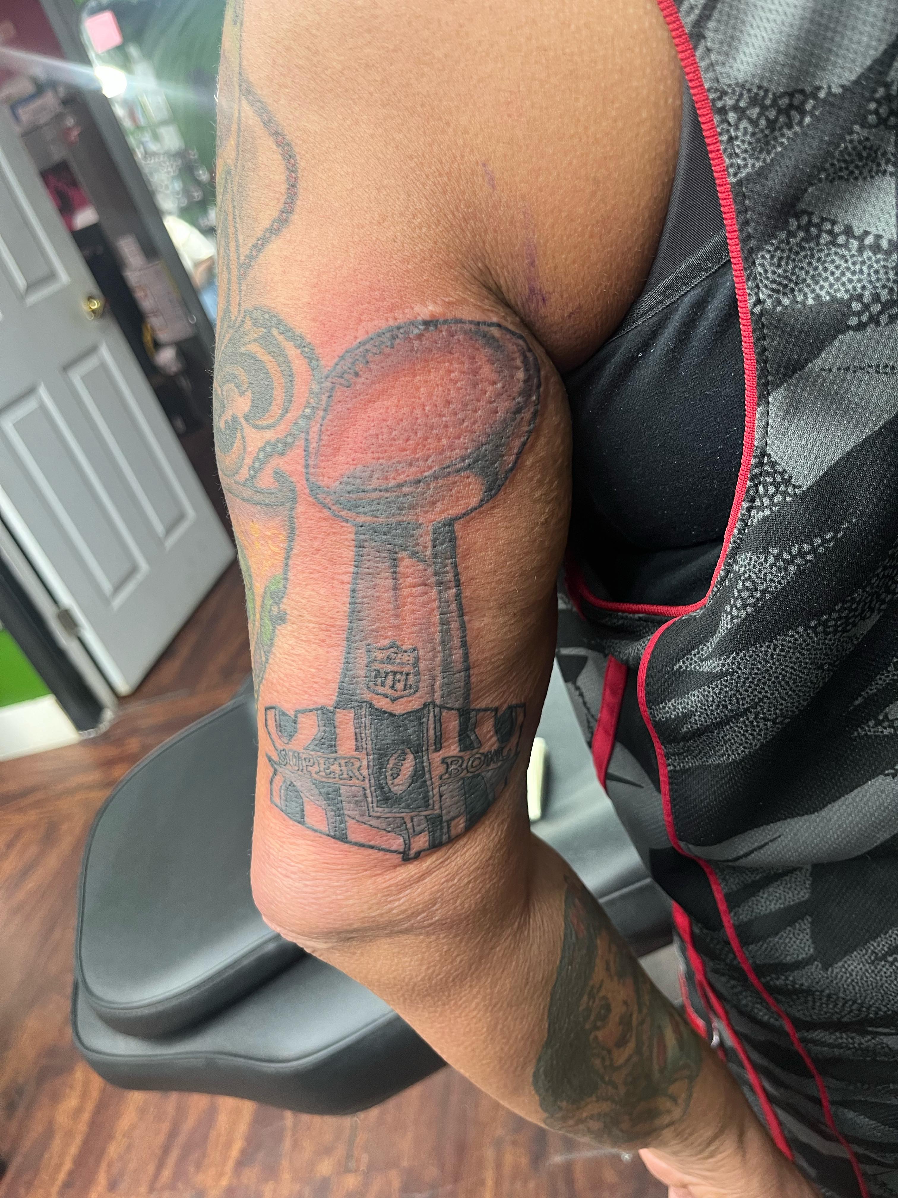 Super bowl trophy black and grey tattoo on the forearm by Darius Armour (Tattoo Artist)